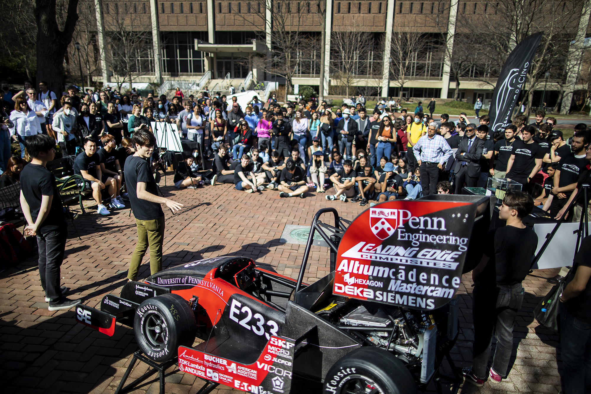Members of the Penn Electric Racing team showing the new racecar, REV7, on College Green to a crowd of students. 