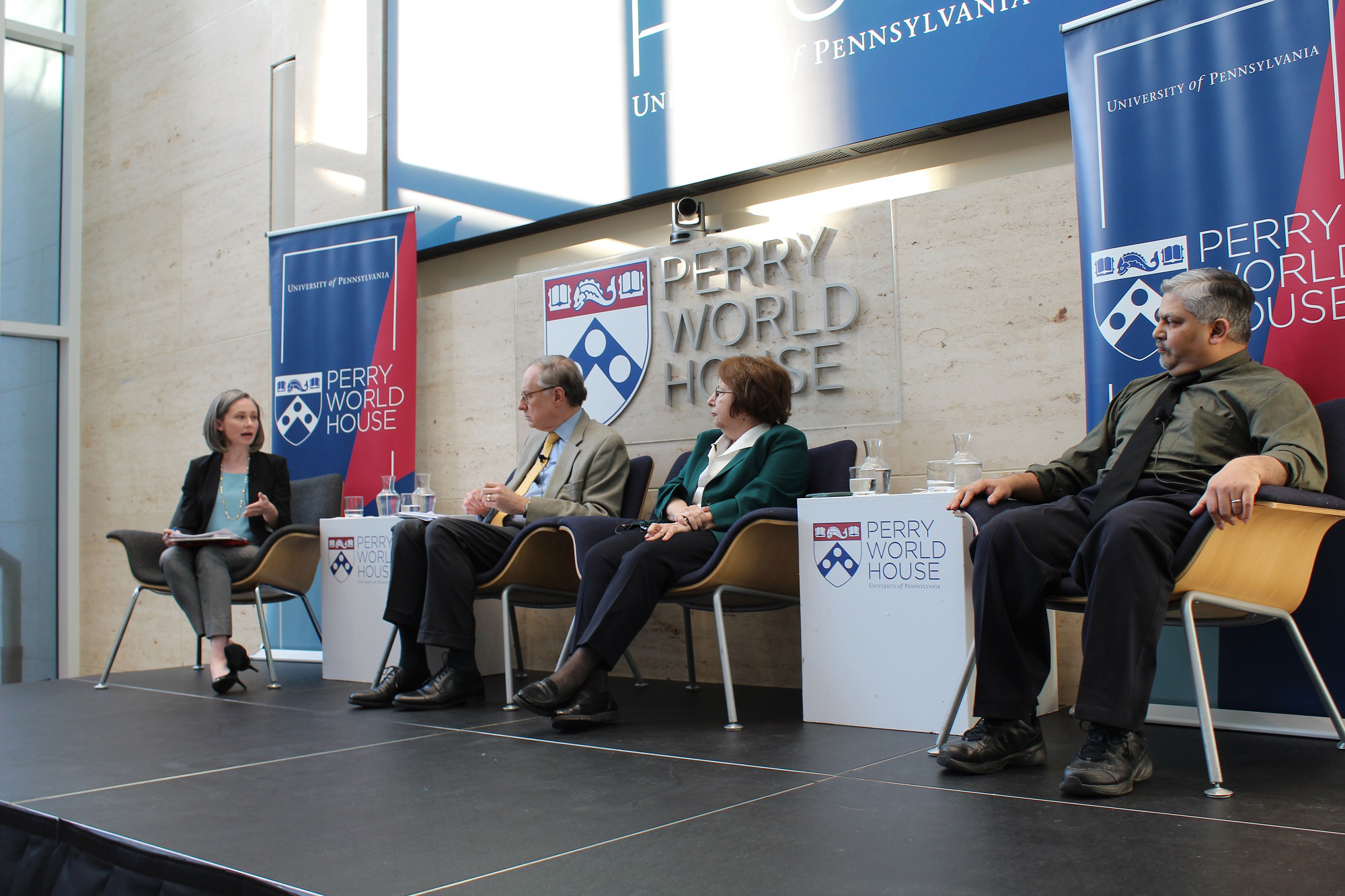 Four people seated on stage at Perry World House.