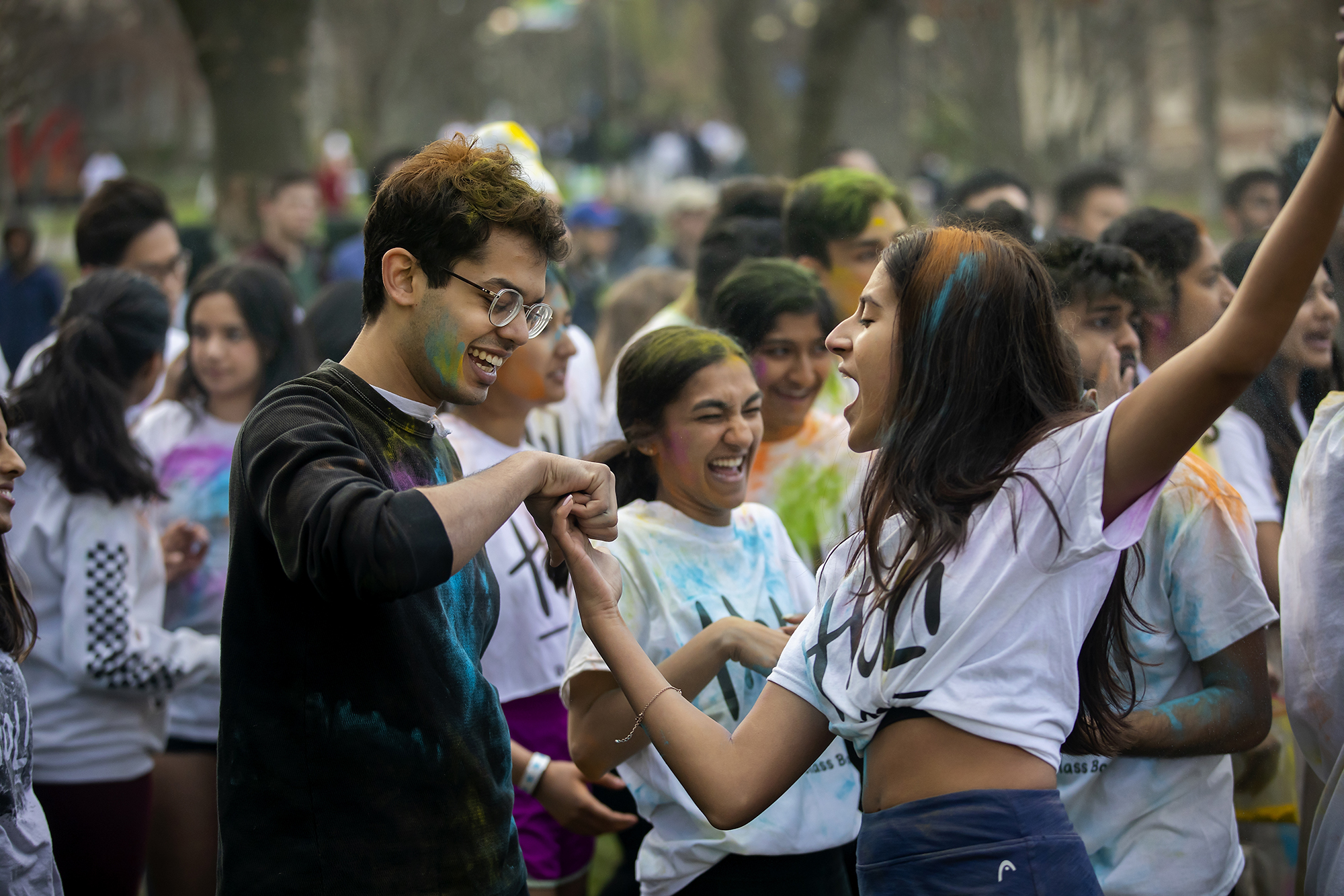 Students cheer after throwing colorful powder on College Green during Penn’s Holi celebration.