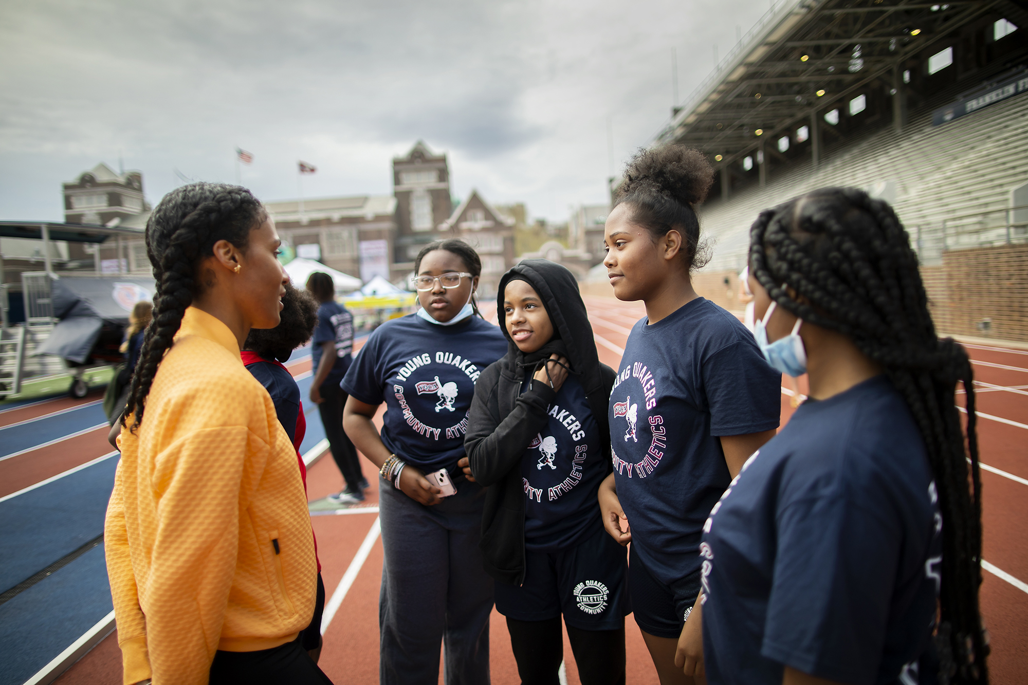 Ajee’ Wilson talking with 4 students from the Lea girls 4x100 team at Franklin Field.