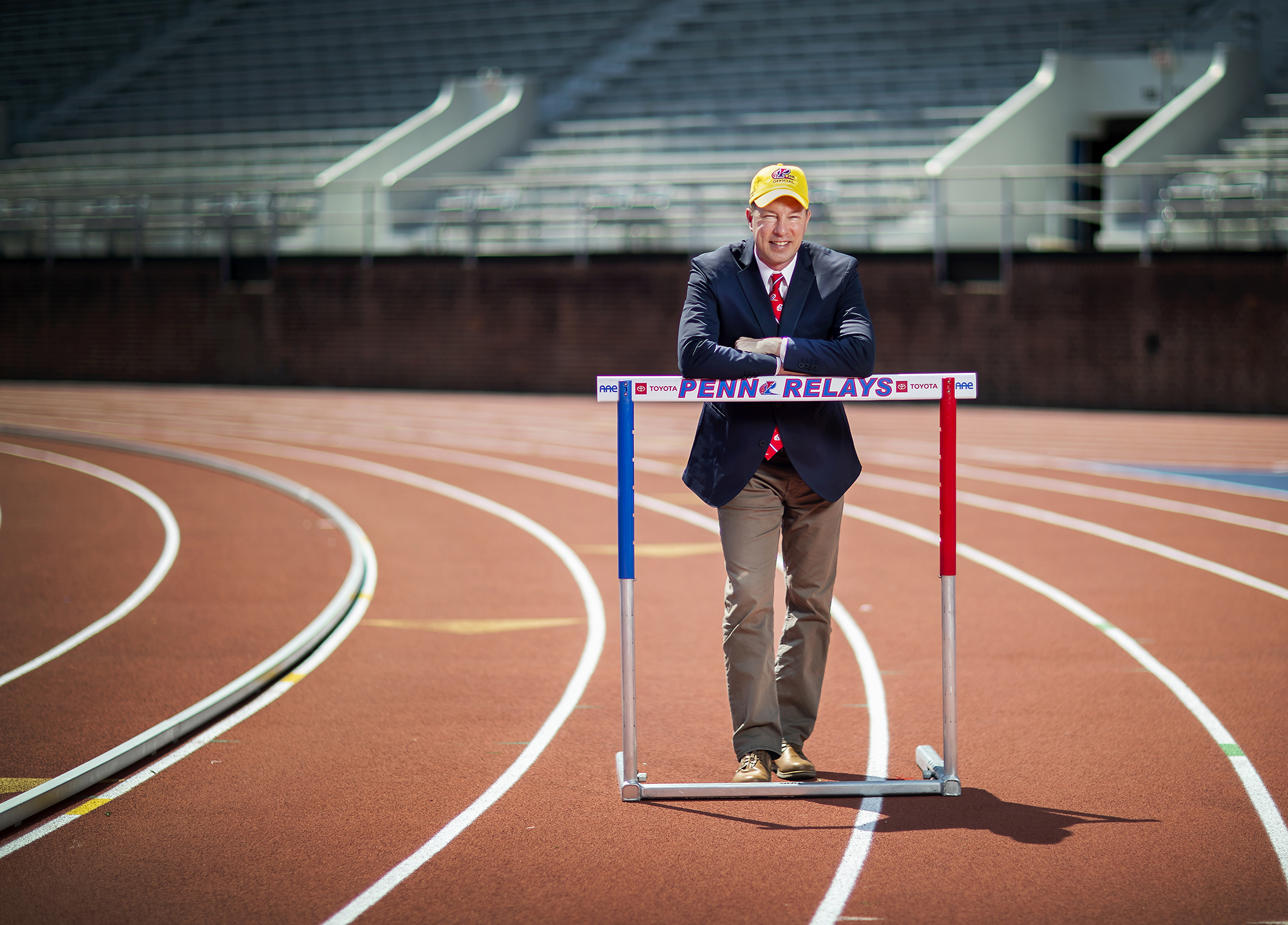 Dolan rests on a hurdle bar on the track at Franklin Field.