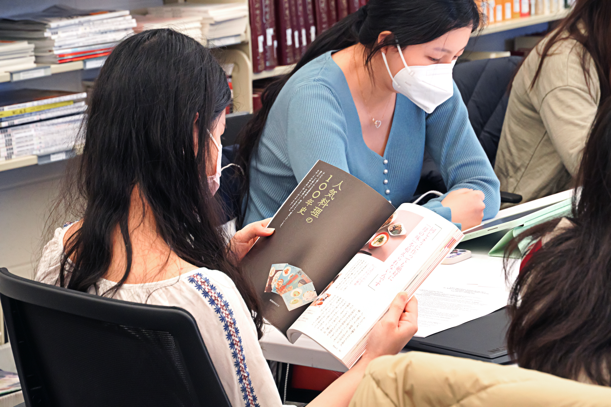 Students in face masks look at Japanese food books in Van Pelt Library