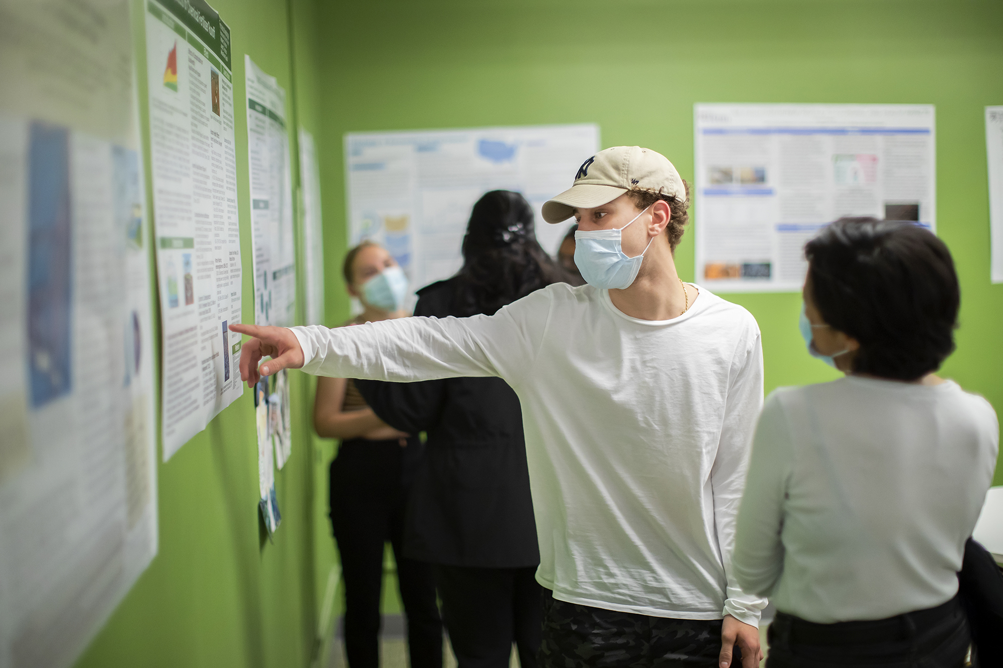 student pointing to a poster in the climate change class