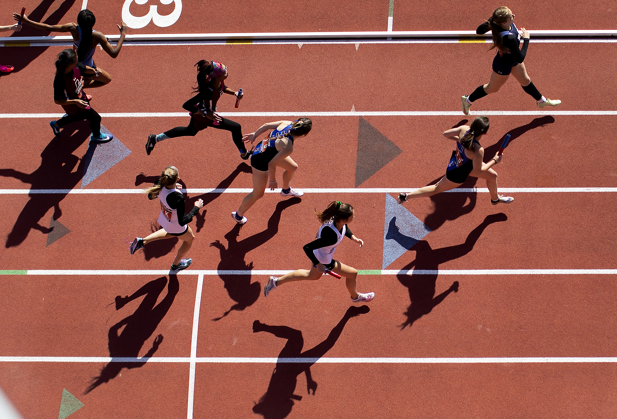 Overhead view of runners running a race on a track.