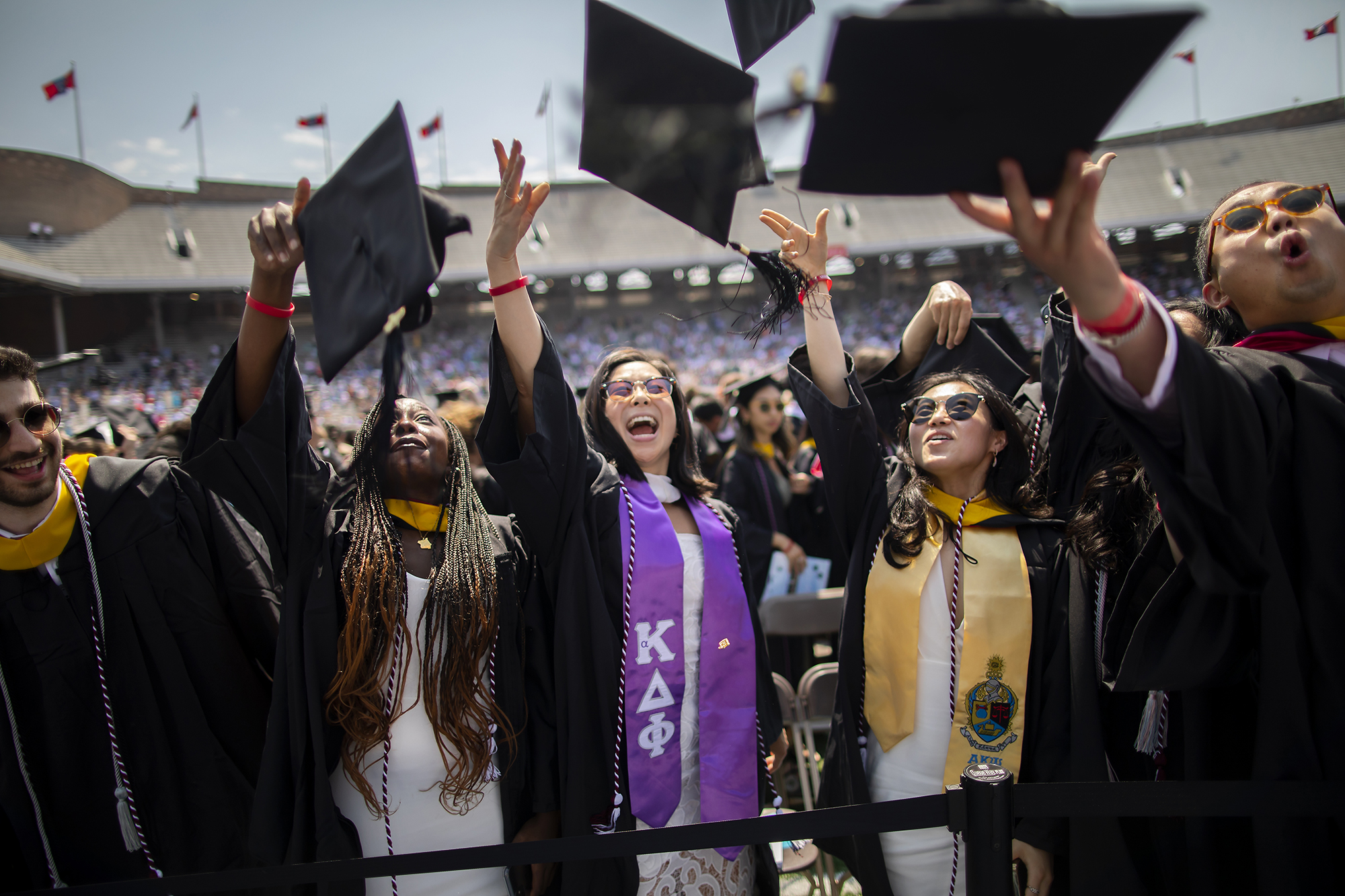 graduates toss caps at commencement