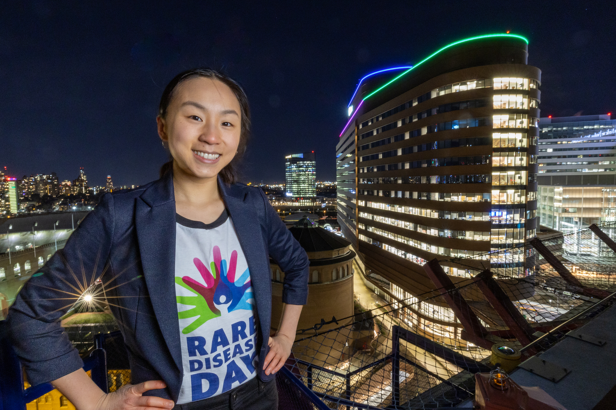 Magnolia Wang posing with Penn Pavilion with the roof lit up