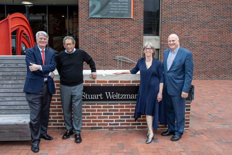 Fritz Steiner, Stuart Weitzman,  Cindy Sanders, and Craig Carnaroli standing outside Weitzman Plaza by a plaque that reads Stuart Weitzman.