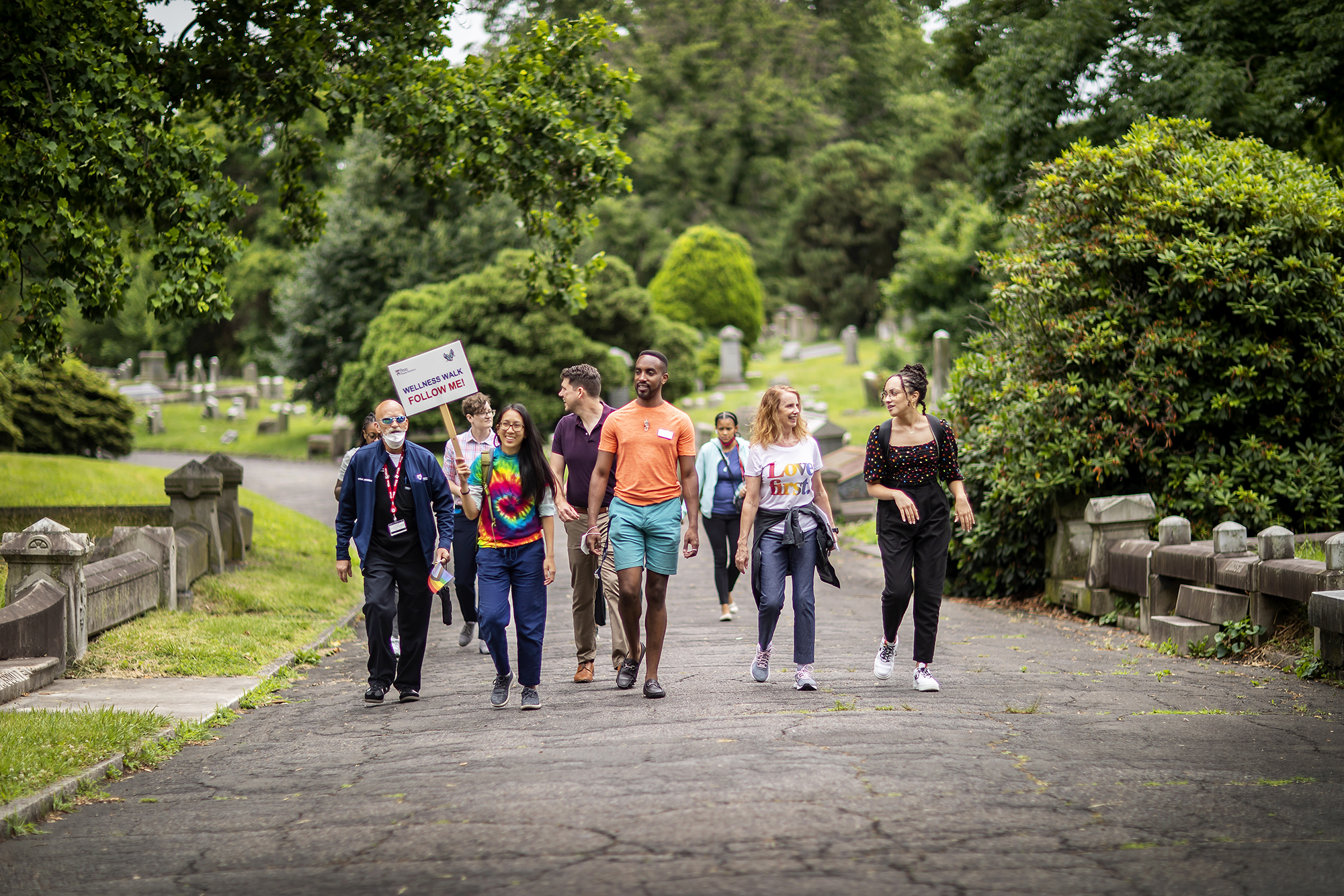 A group of people walk down a wooded road