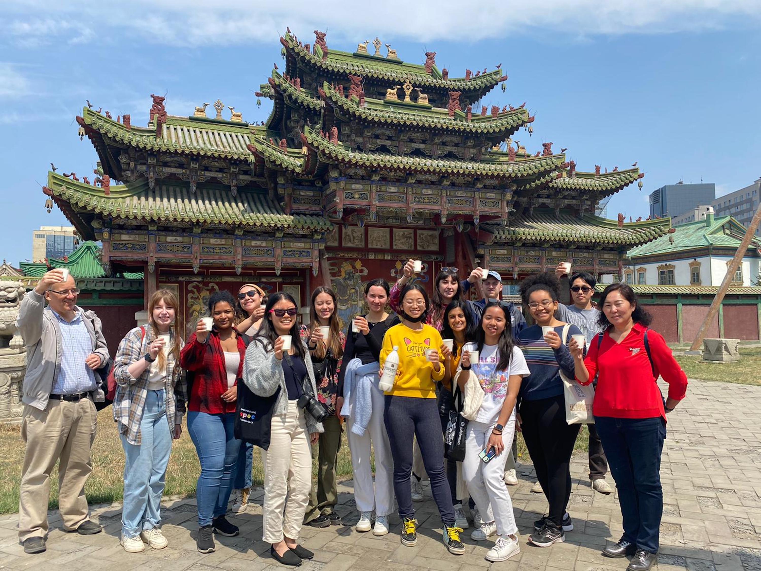 Penn Global seminar students hold up cups outside the Winter Palace 