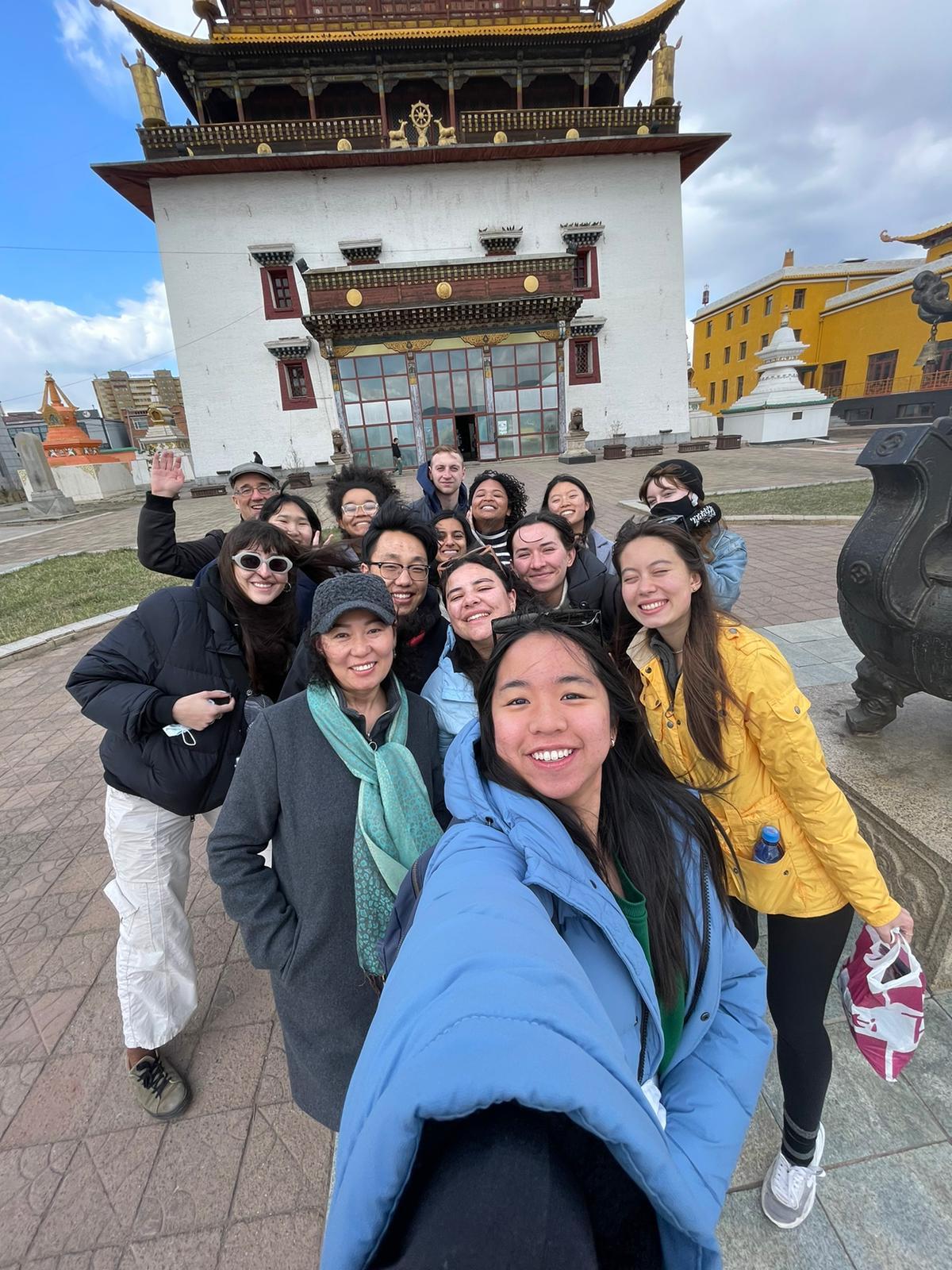 Students take a selfie in front of a temple in Ulaanbaatar, Mongolia