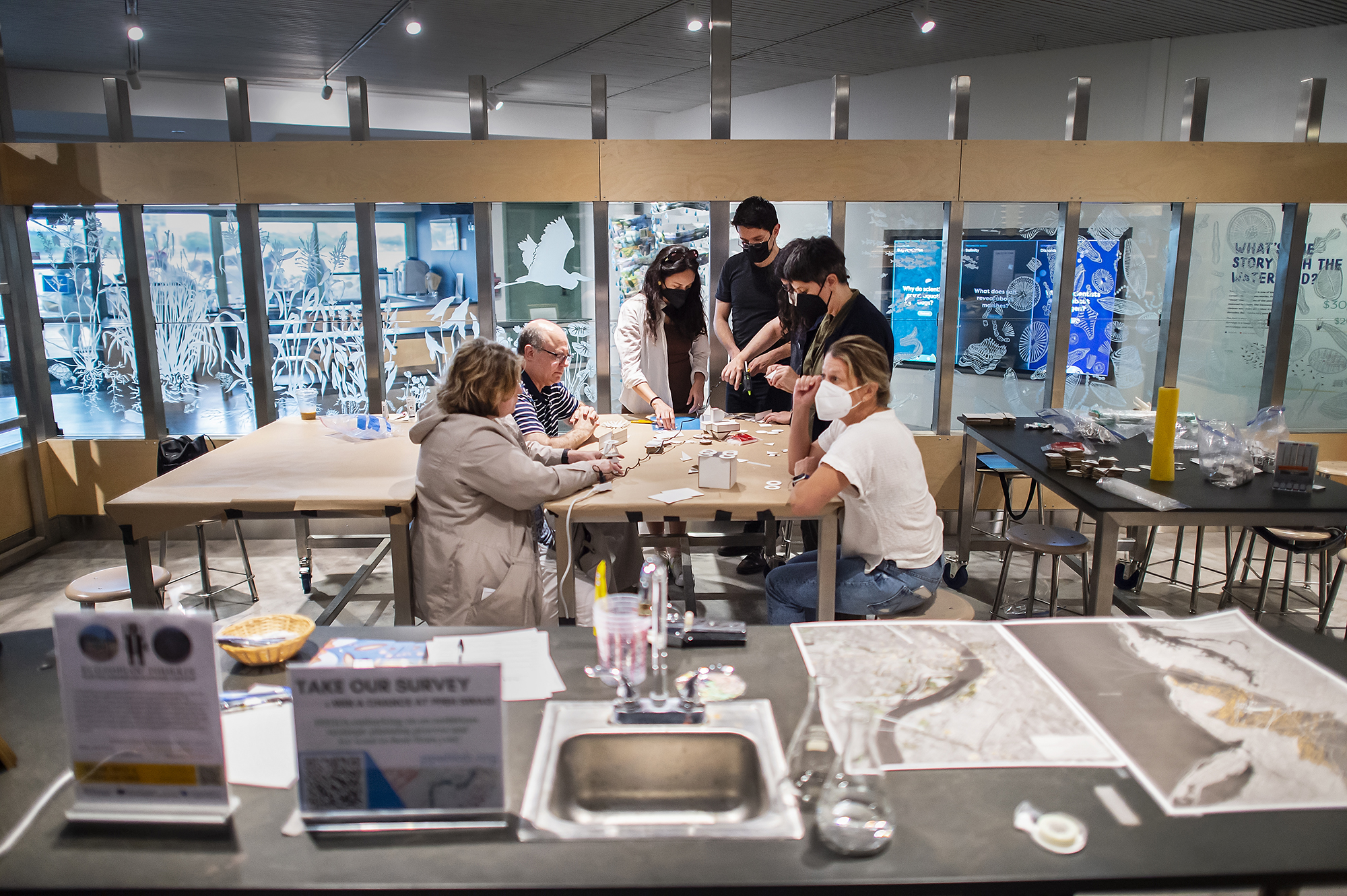 Seven people around a table in a lab.