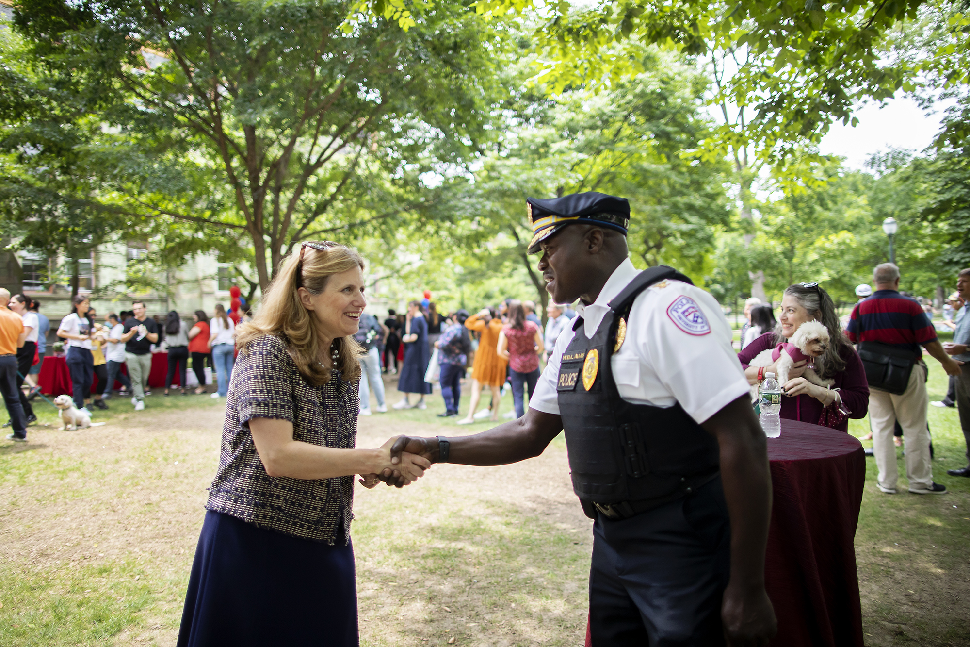 Penn President Liz Magill shakes hands with a Public Safety officer on College Green.