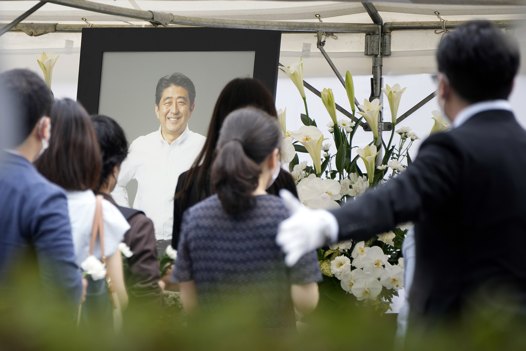 People queue to offer flowers and prayers for former Prime Minister Shinzo Abe, at Zojoji temple prior to his funeral on July 12, 2022, in Tokyo.