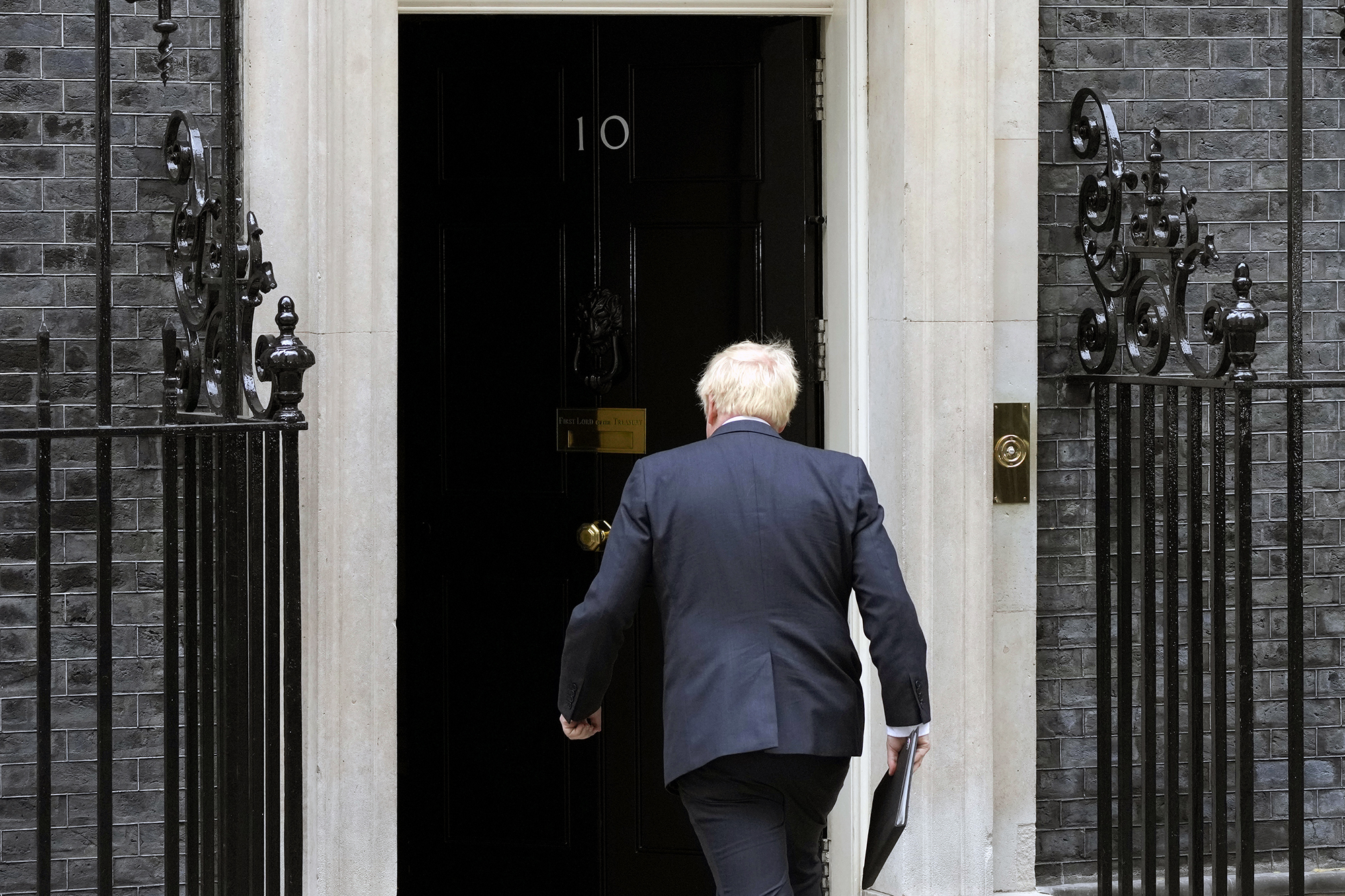 UK Prime Minister Boris Johnson heads toward the front doors of 10 Downing Street in London