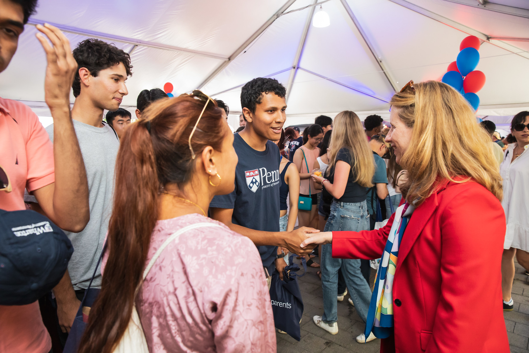 Penn President Liz Magill shakes hands with a new student.