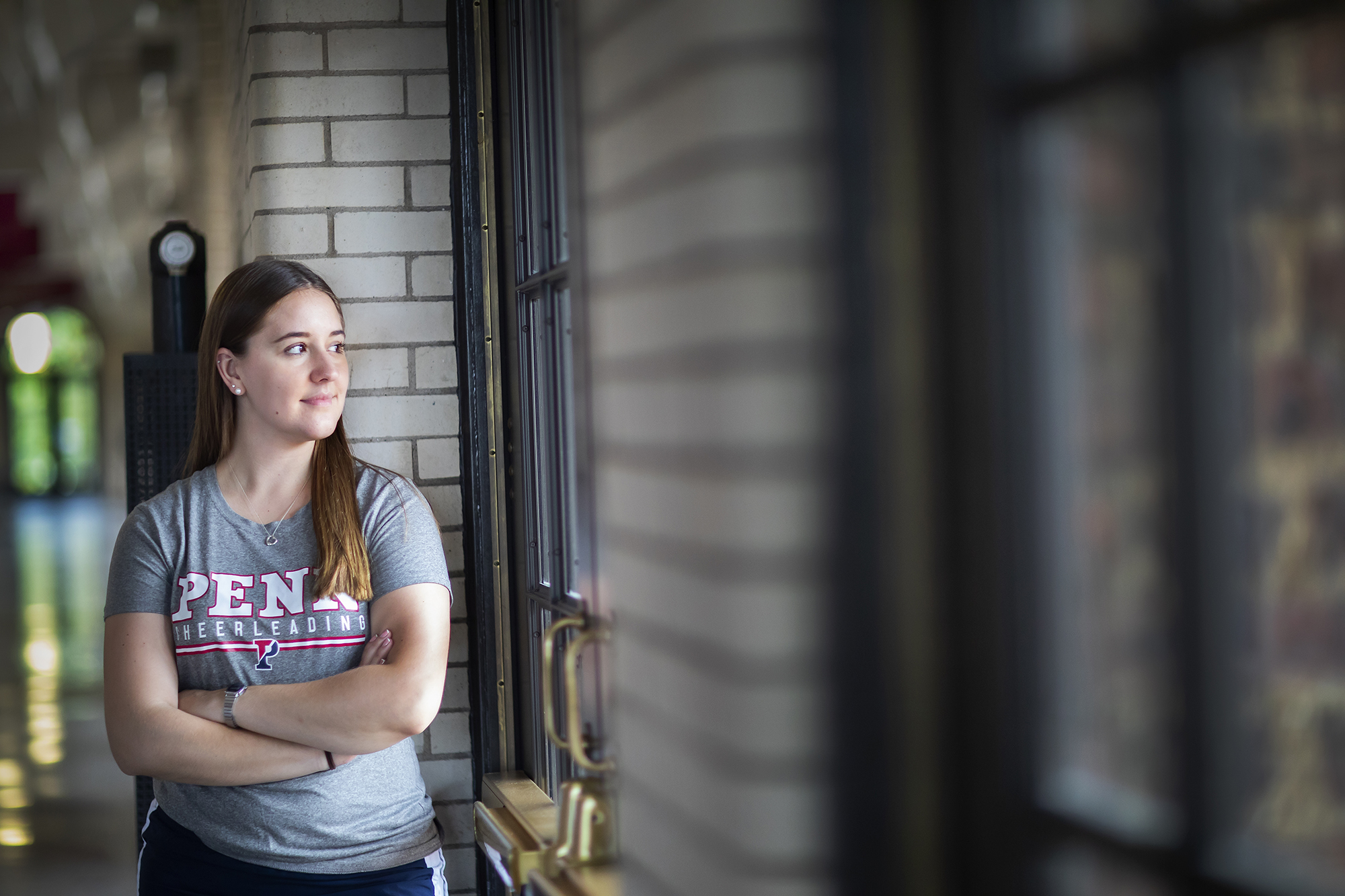 Sophia Zehler looks out a glass door at Penn’s Palestra.