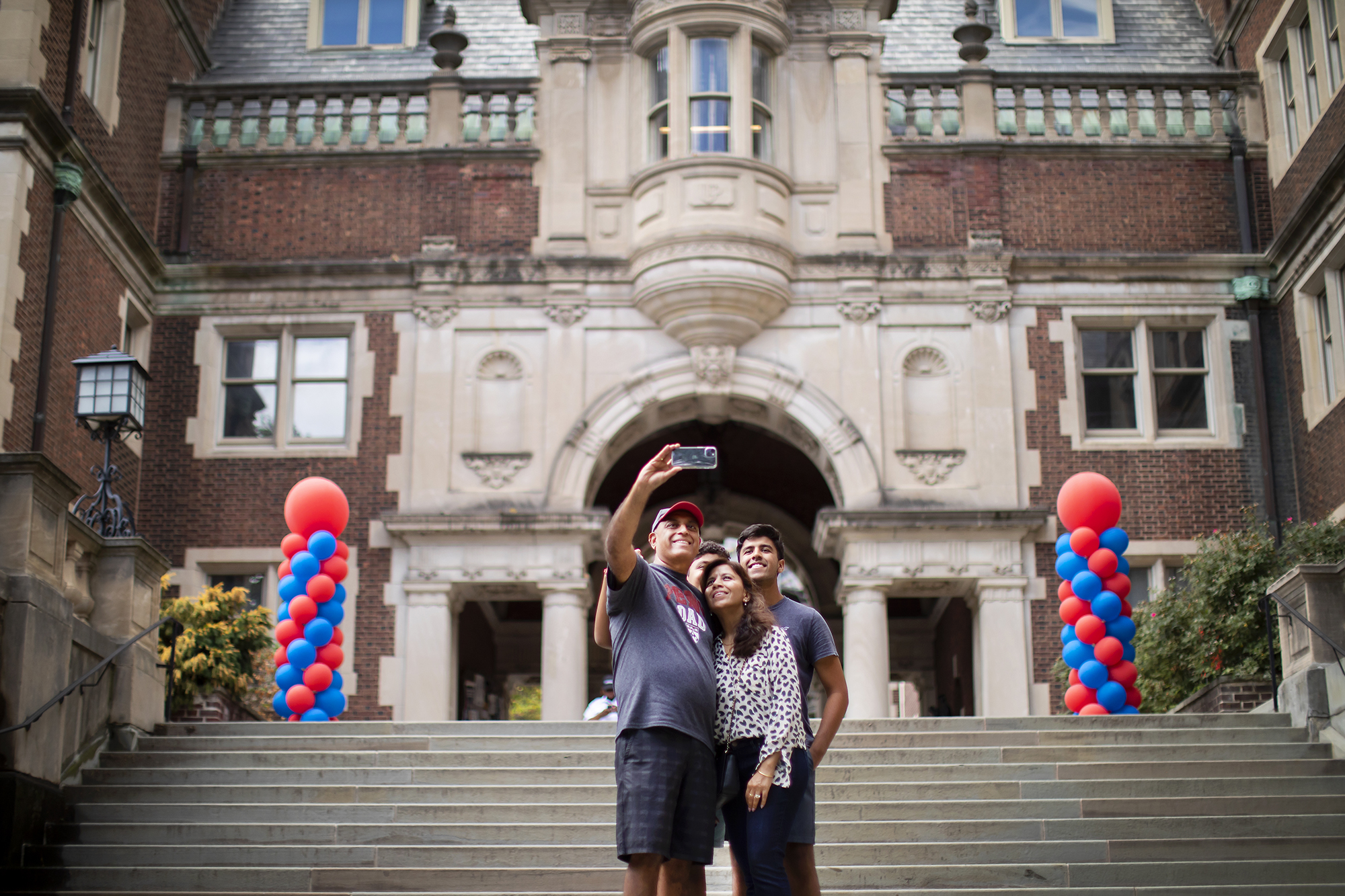 penn family taking a selfie on the upper quad steps