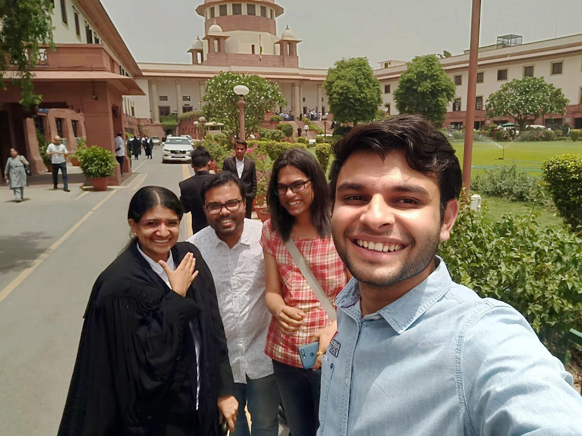 Udai Bhardwaj and three lawyers smiling in front of the Indian Supreme Court.