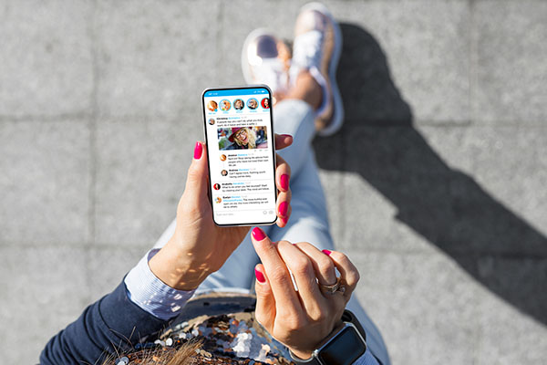 Perspective of person who is looking down at a phone with social media on screen.