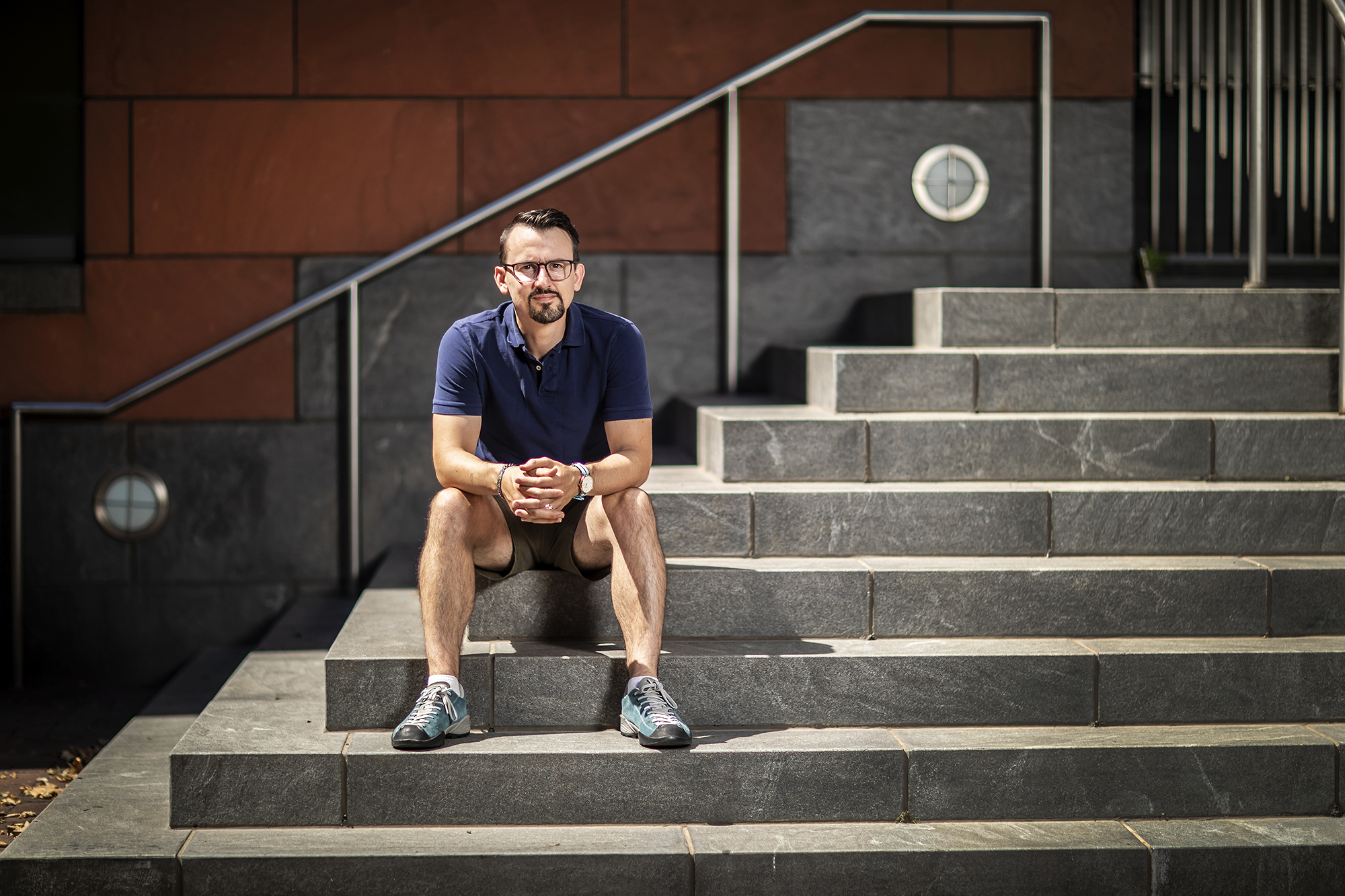 Psychologist Jer Clifton sits on the steps of his office