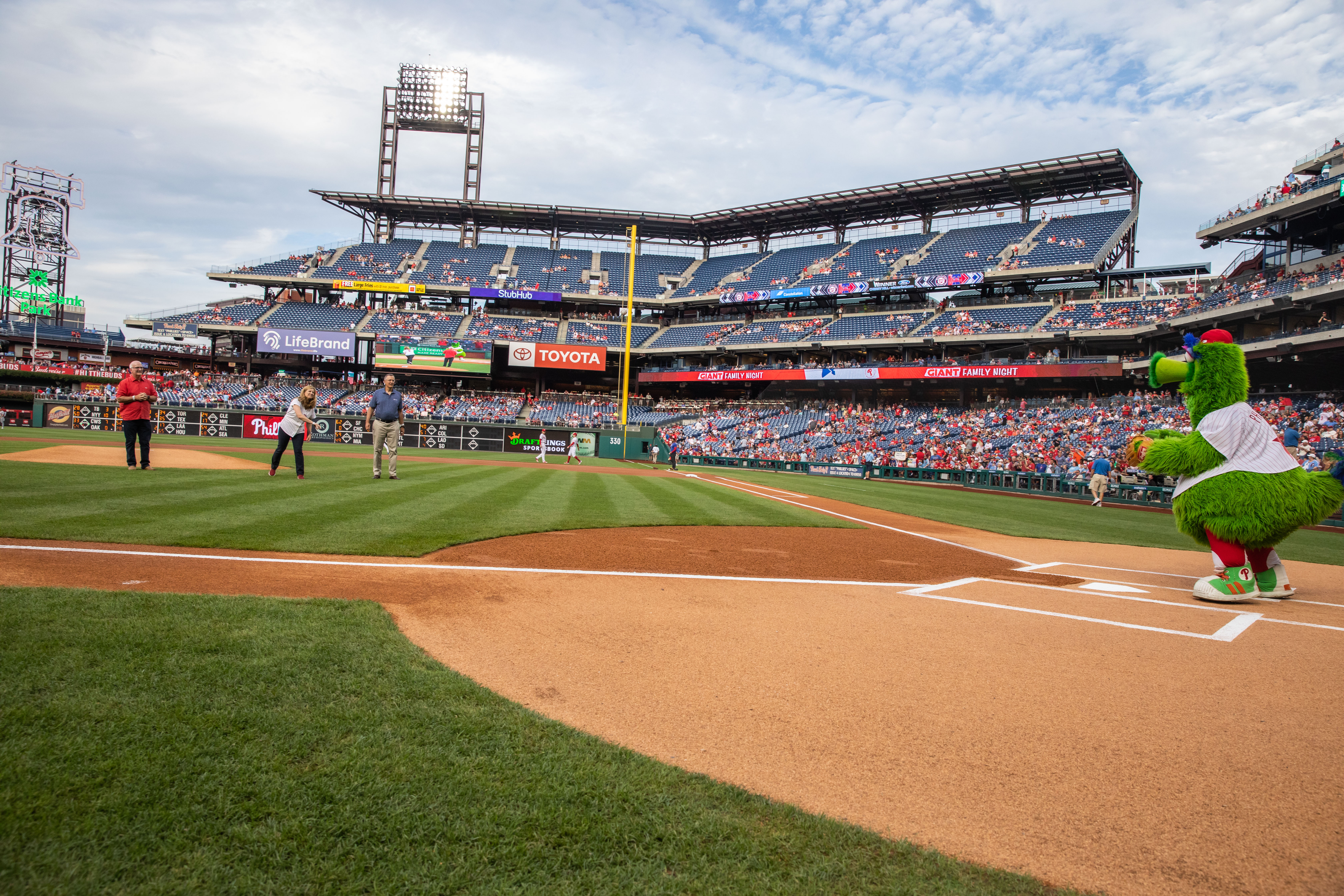 Liz Magill throws the first pitch on the field to the Phanatic