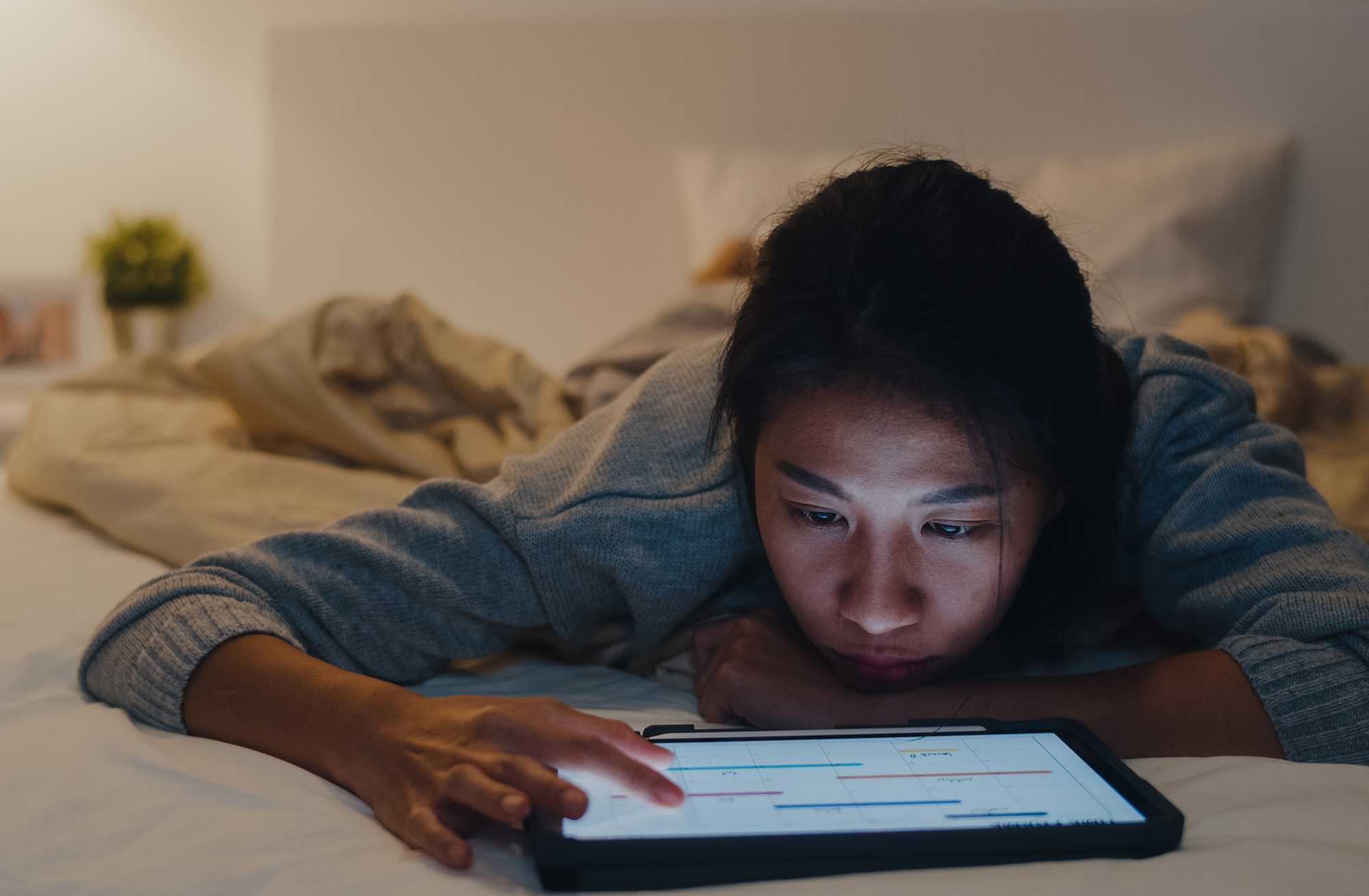 Person laying in bed on a laptop.