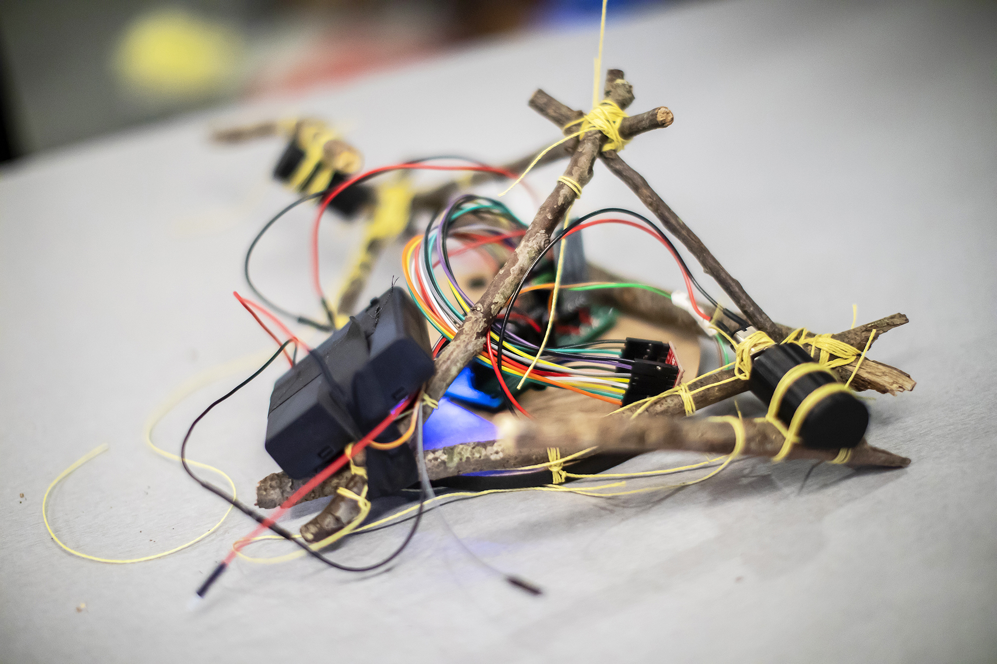 A small robot made of wires and tree twigs.