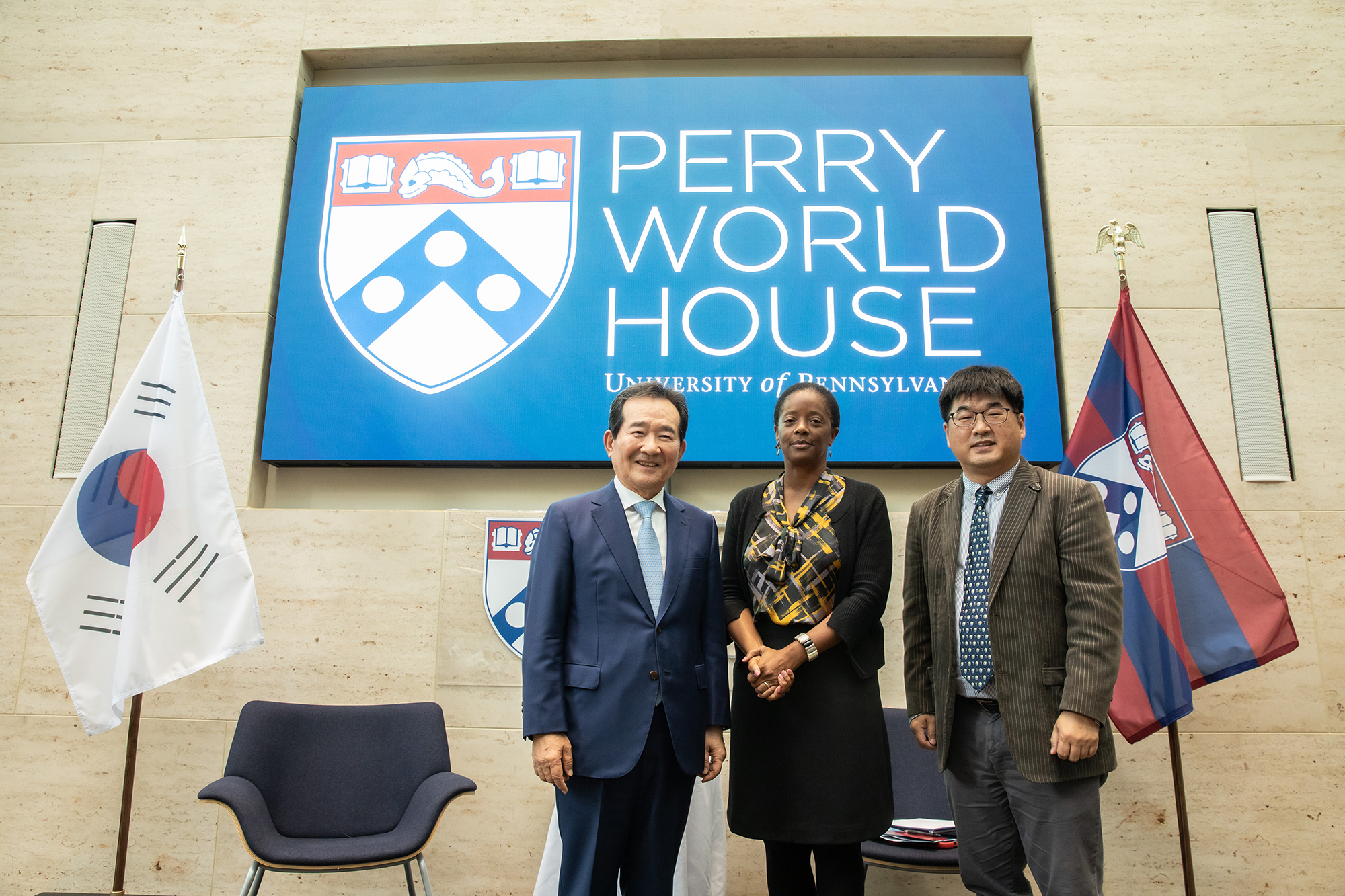 Chung Sye-kyun stands on stage at Perry World House with two other people presenting the talk.