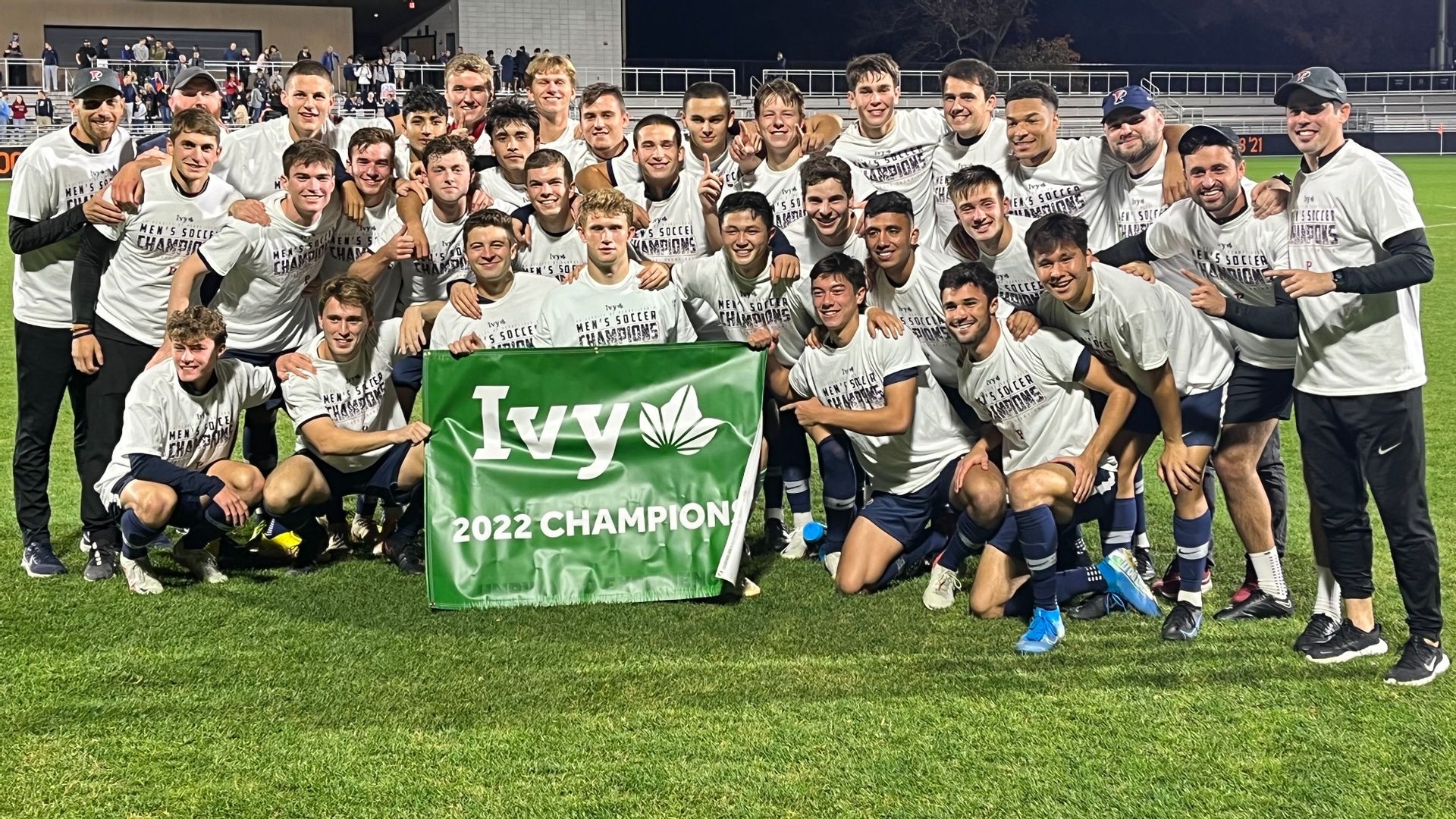 The men's soccer team poses with the 2022 Ivy champion banner.