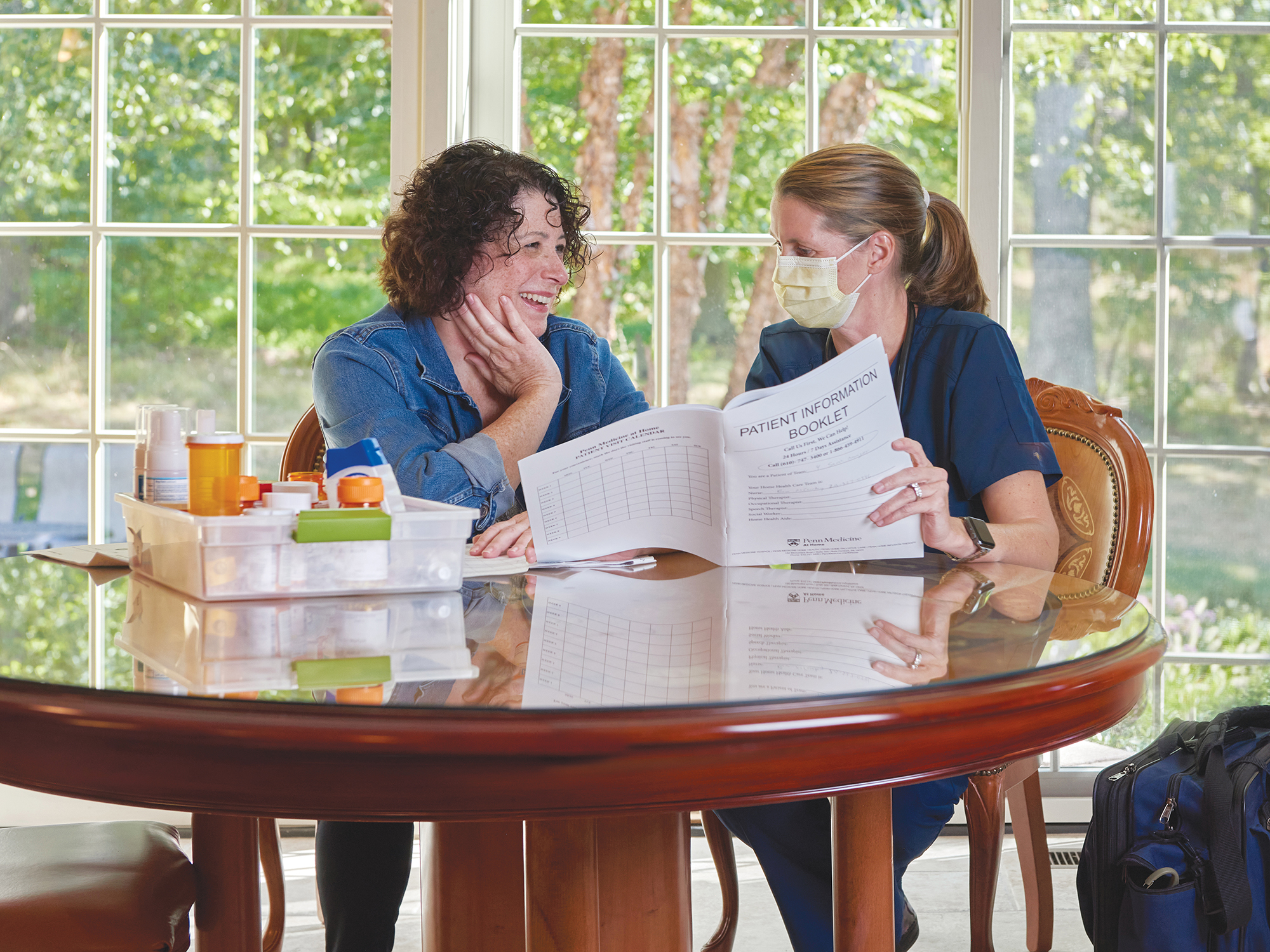 nurse talking with patient at home kitchen table
