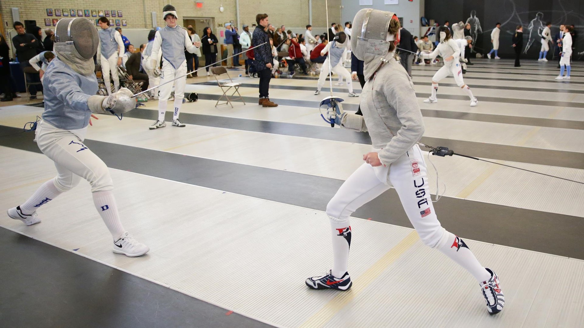 A Penn fencer duels with a Duke fencer.