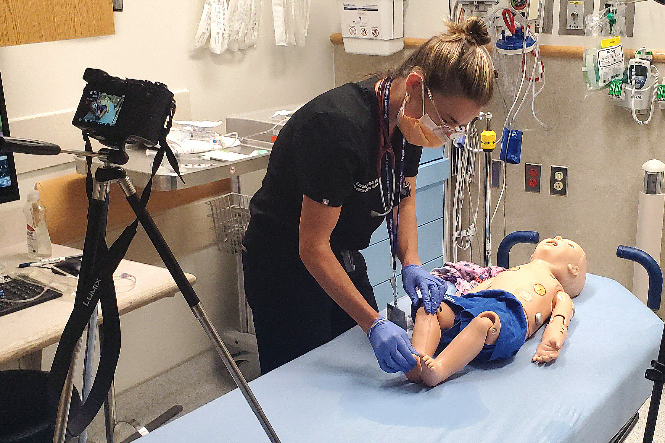 A video camera records Elizabeth Sanseau practicing medical care on a mannequin. (Image courtesy of Kyle Cassidy)