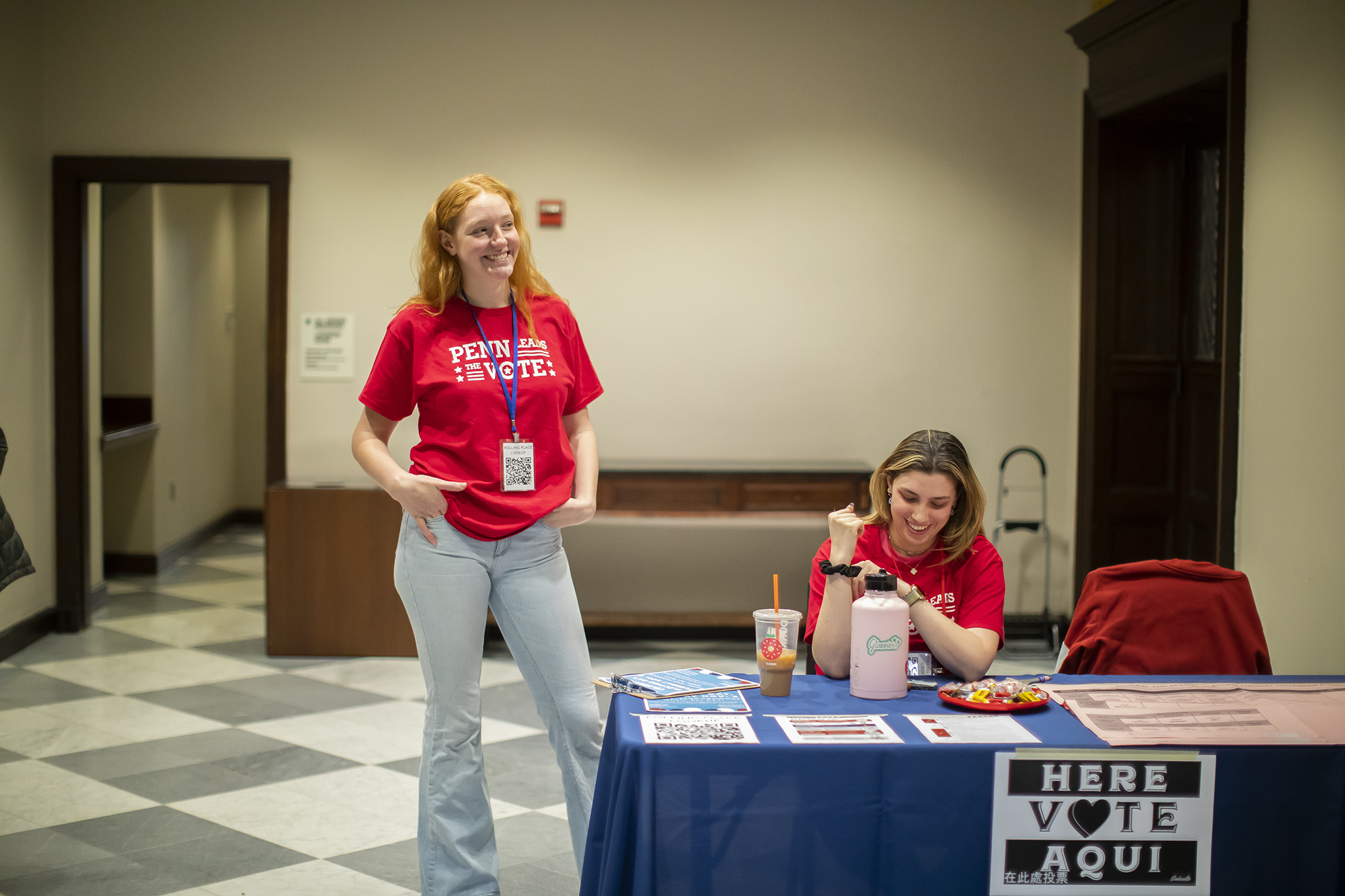 Two members of Penn Leads the Vote at a table in Houston Hall.