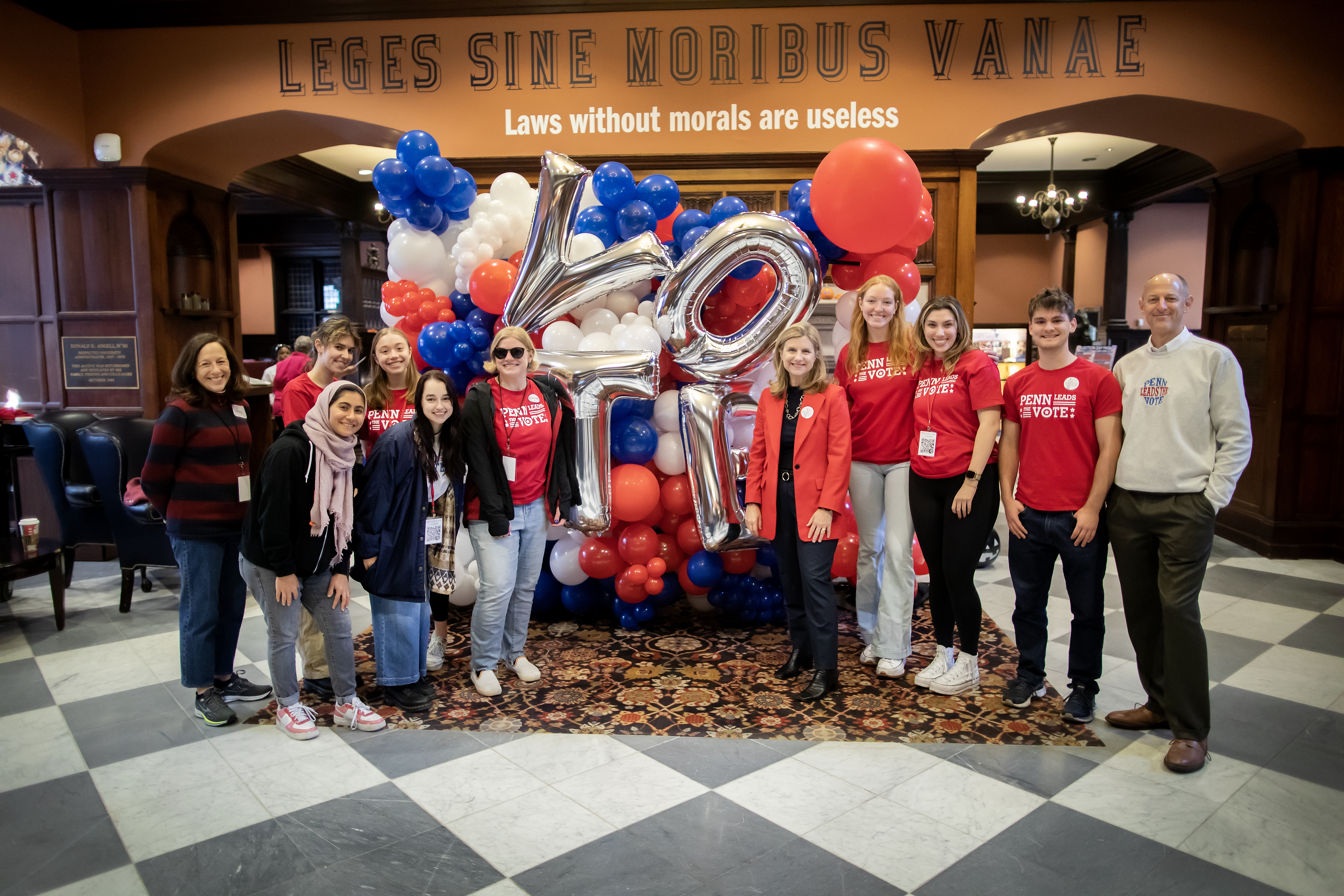 Members of Penn Leads the Vote and Penn President Liz Magill stand in front of a balloon display that reads VOTE in Houston Hall.