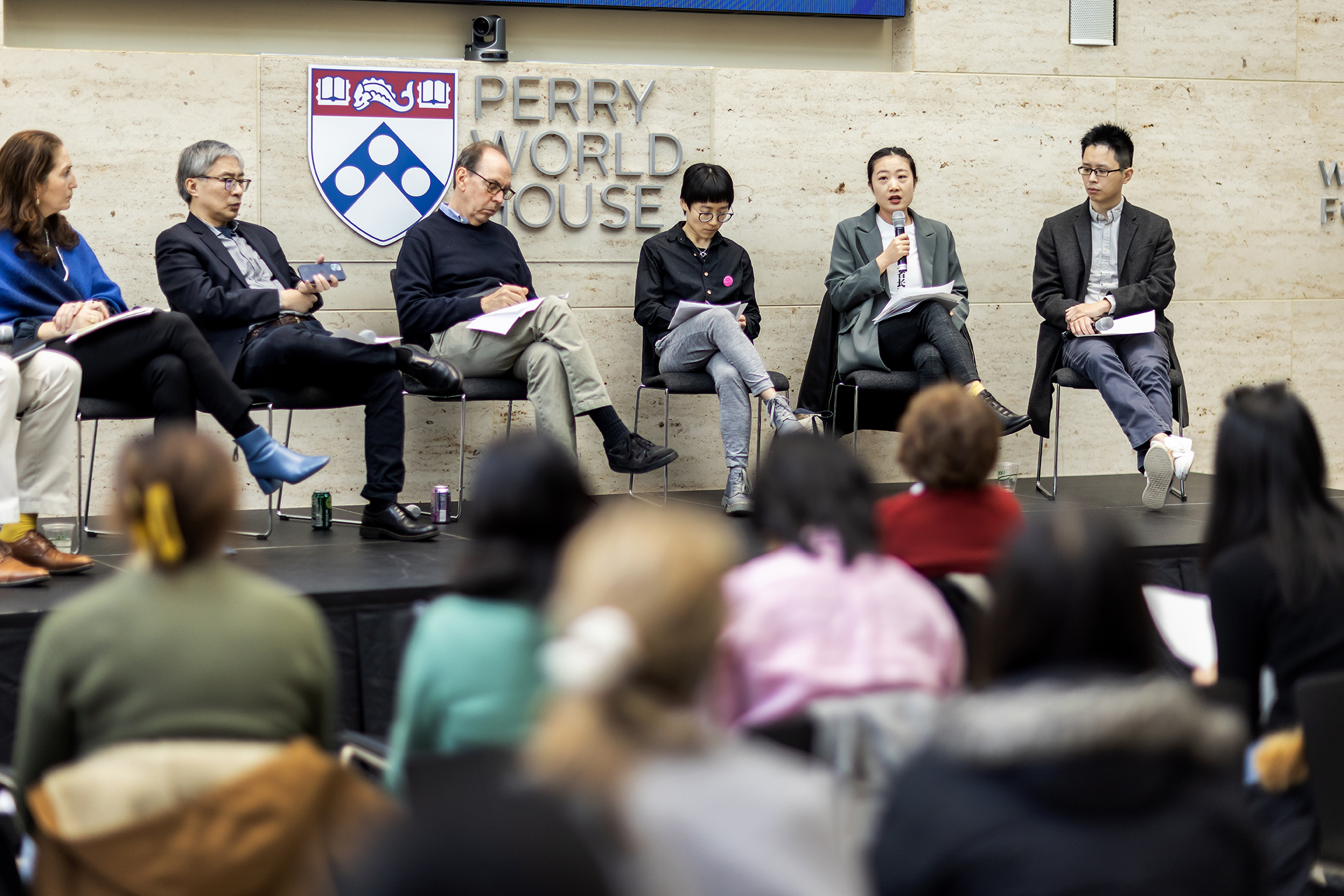 Speakers on a stage at Perry World House discuss the protests in China.