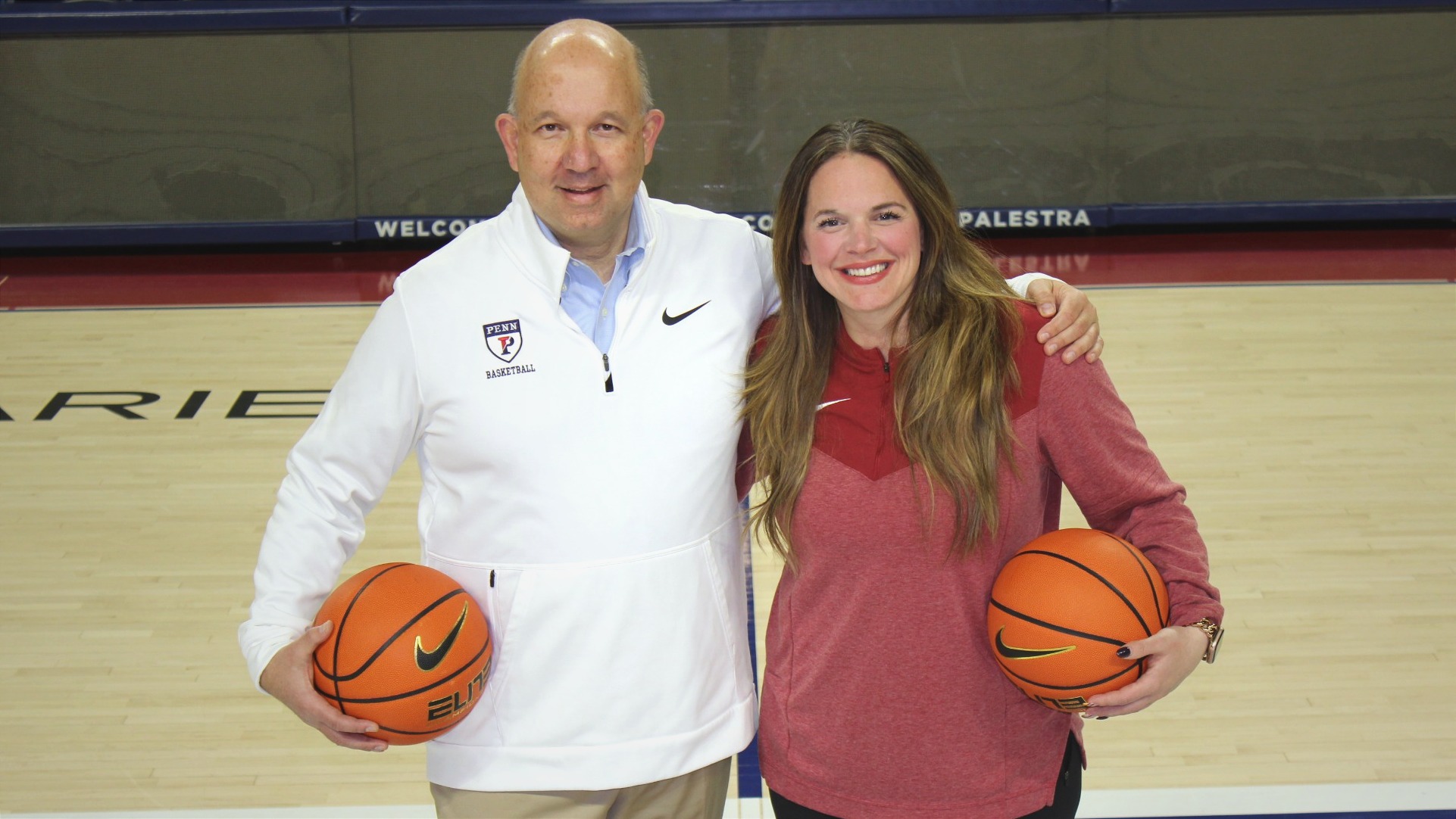 John Di Paolo and Kelly Killion smiling and standing arm-and-arm on the court celebrating the announcement.