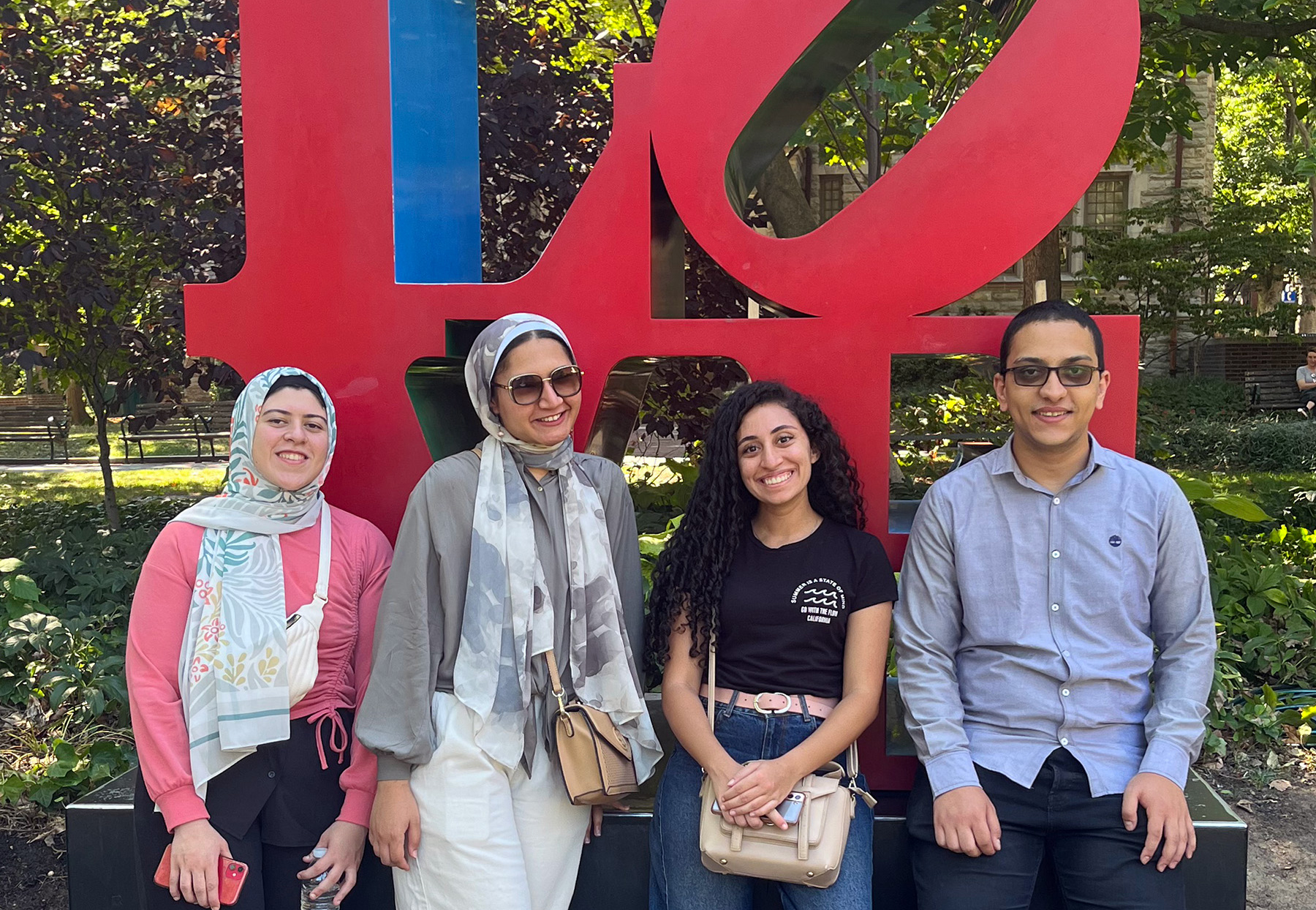 Farah Essam Girat-Allah, Rawan Sleem, Carine Mankarious, and George Habib in front of Penn’s LOVE statue on College Green.