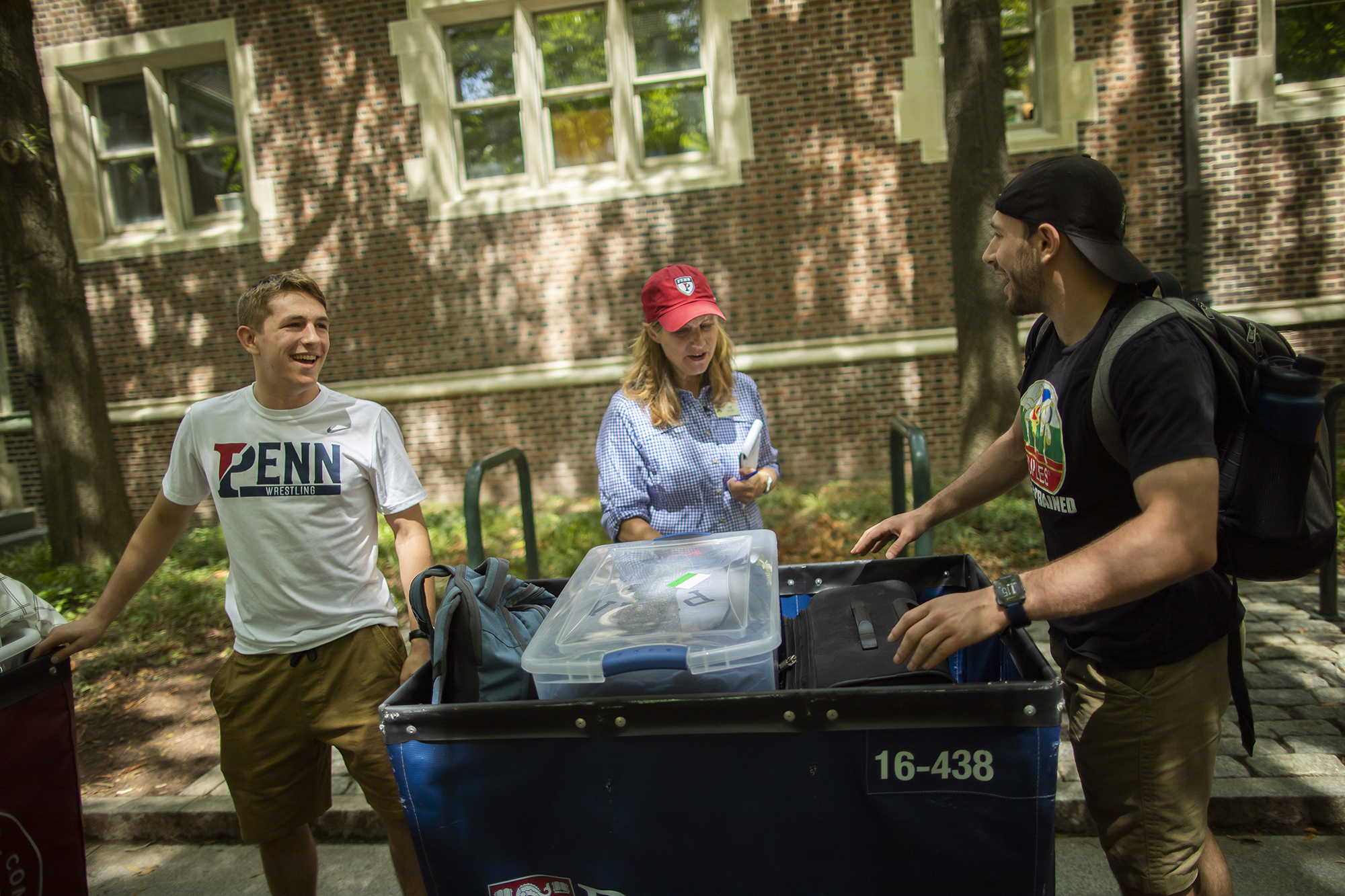 Liz Magill talks with two students moving into campus housing on Move-In day.