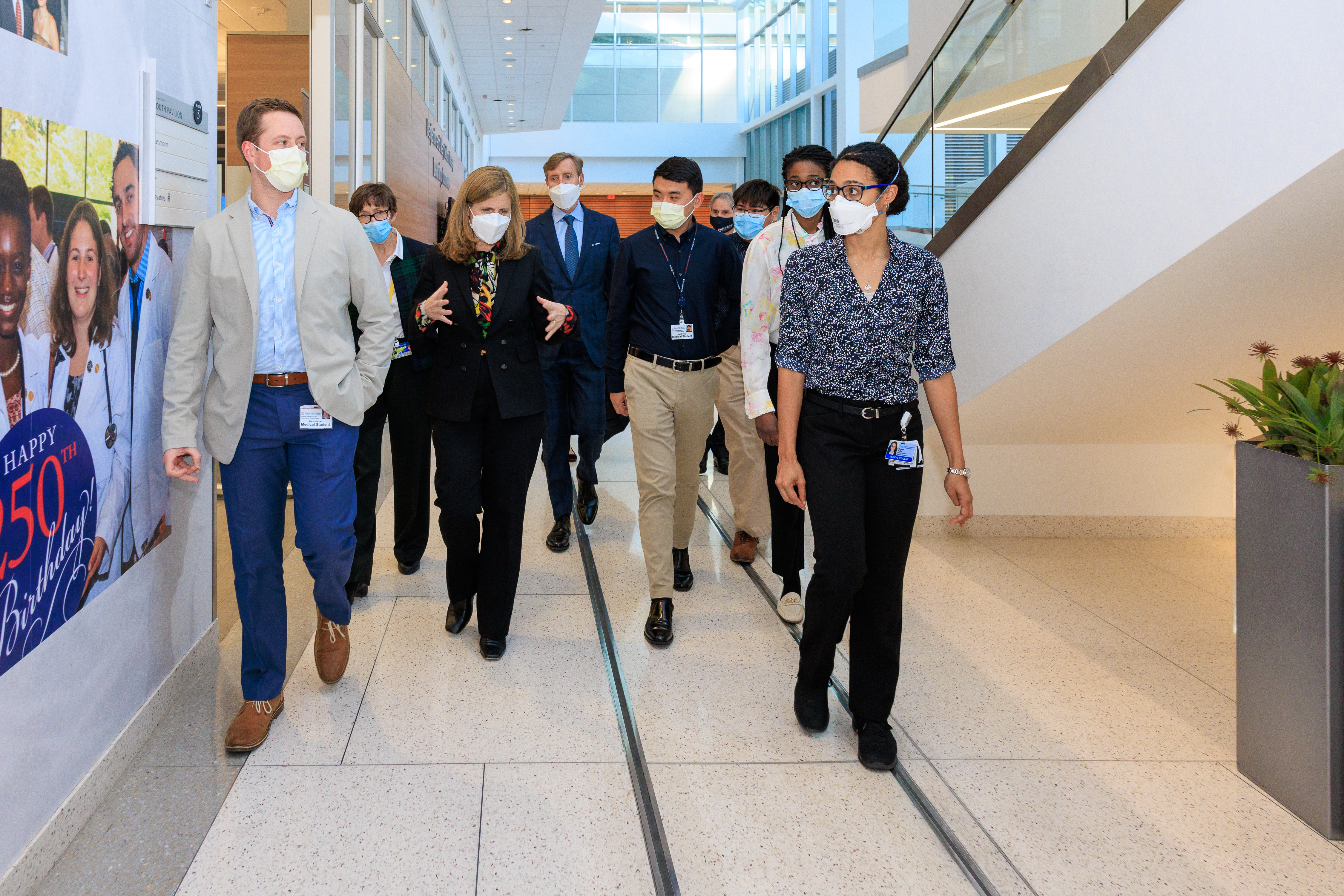 Liz Magill walks through a hallway at Penn Medicine with others.