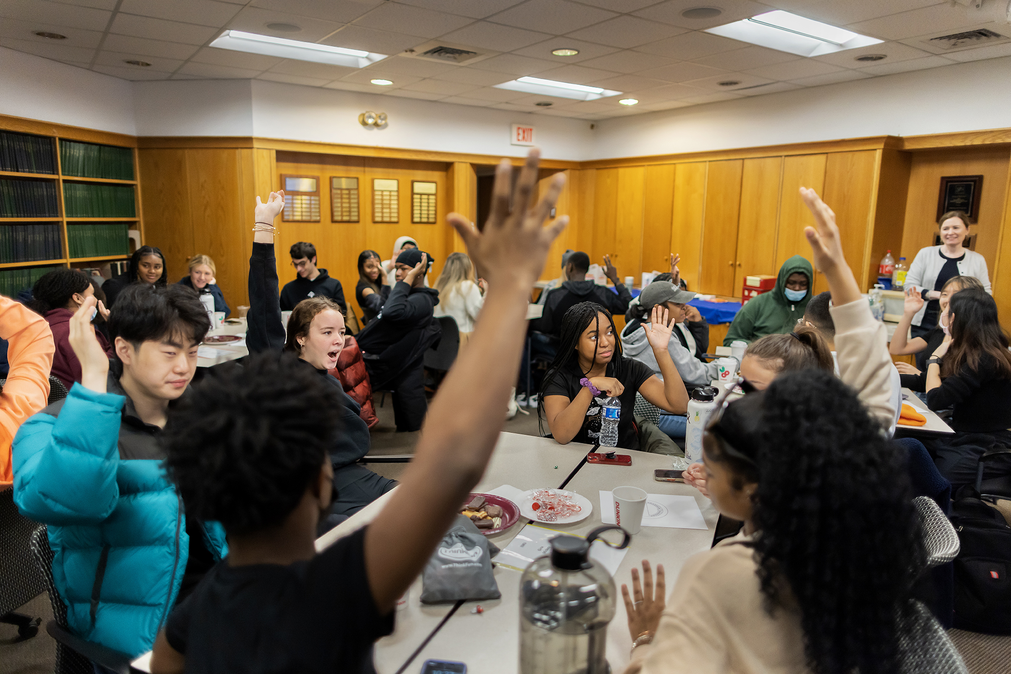 Students from Penn and Robeson High School raise their hands to answer quiz questions.