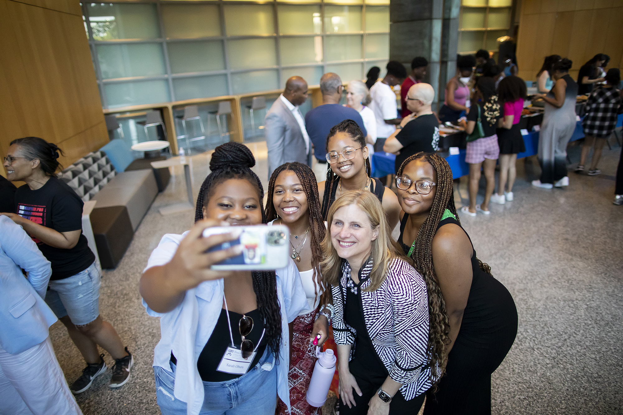 Liz Magill and a group of three people pose for a selfie.