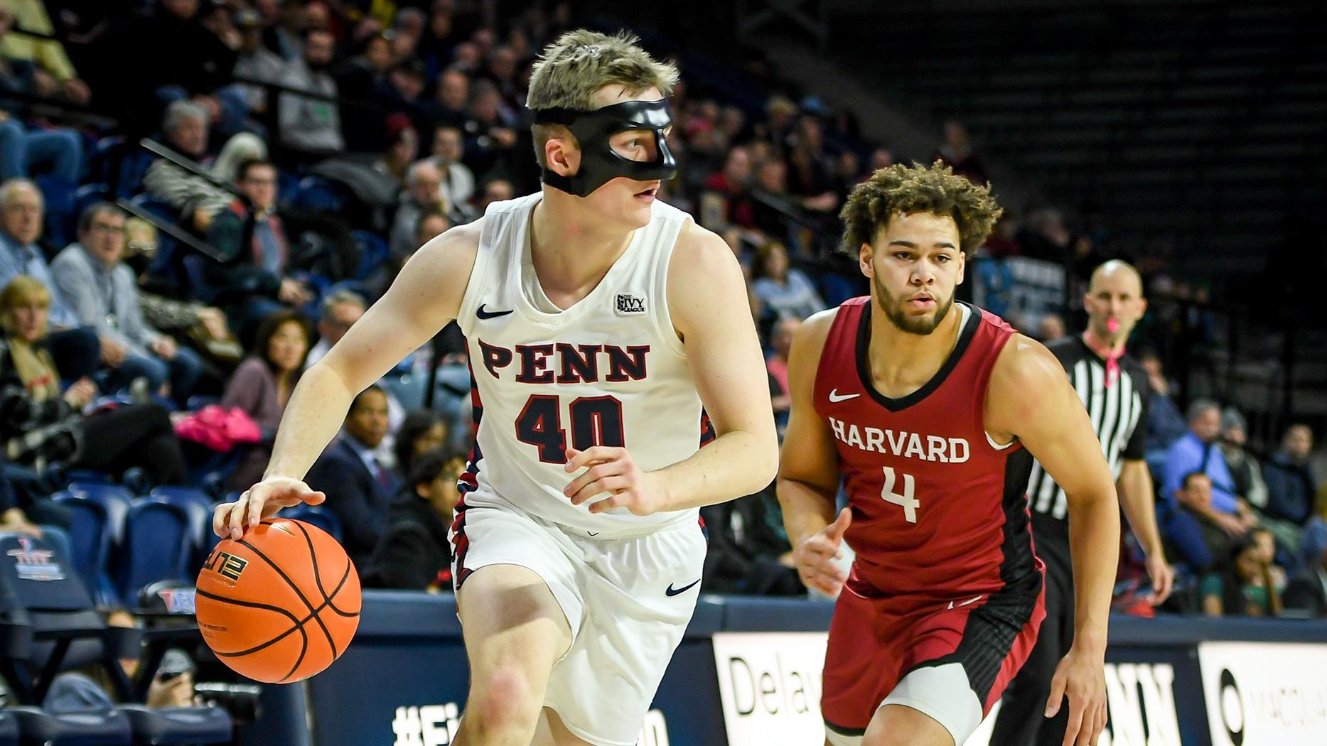 wearing a nose guard, Smith dribbled the ball on a court away from a Harvard player while a referee watched in the background.