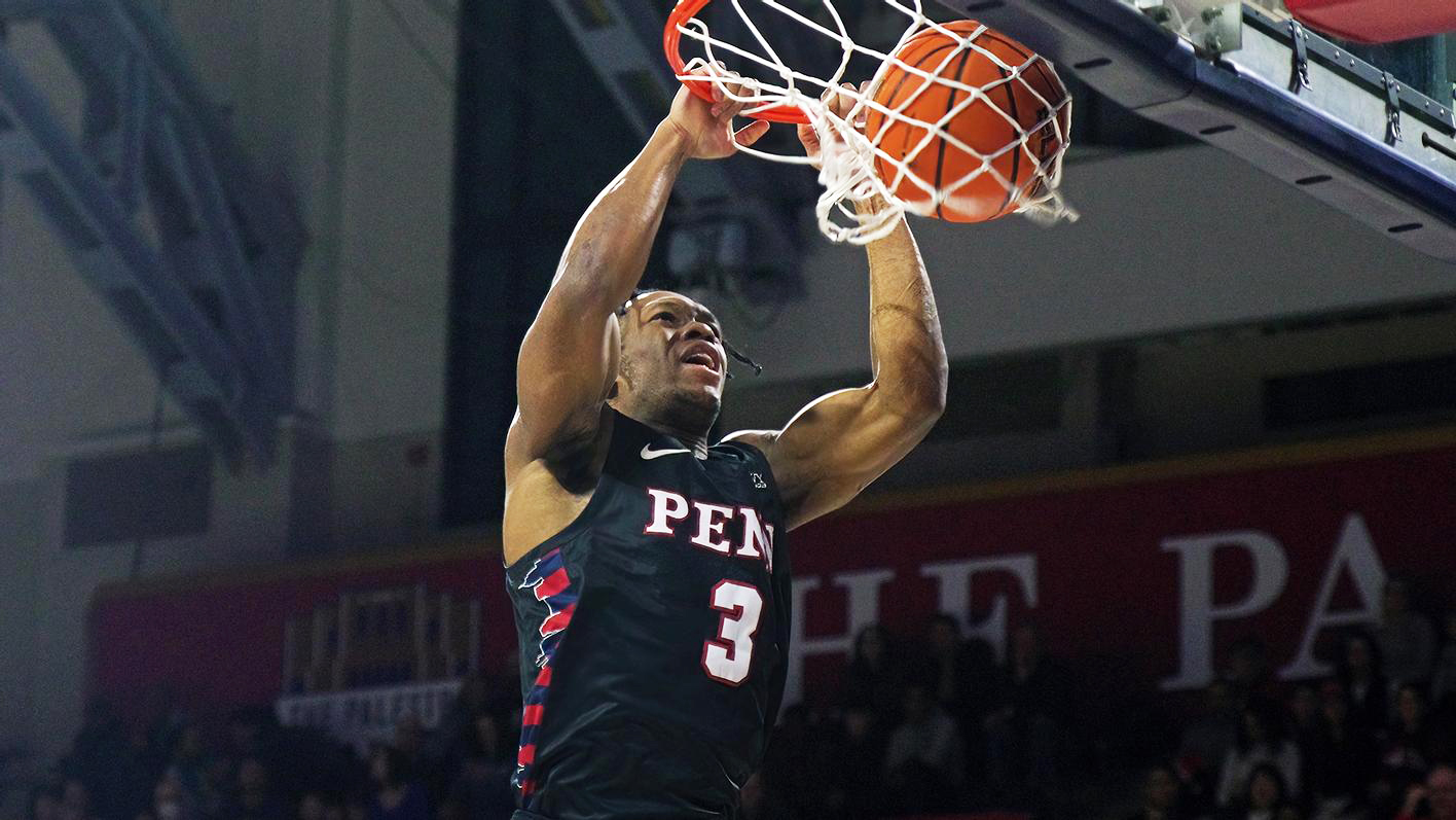 Dingle dunks the ball with his hands, touching the hoop at the Palestra.
