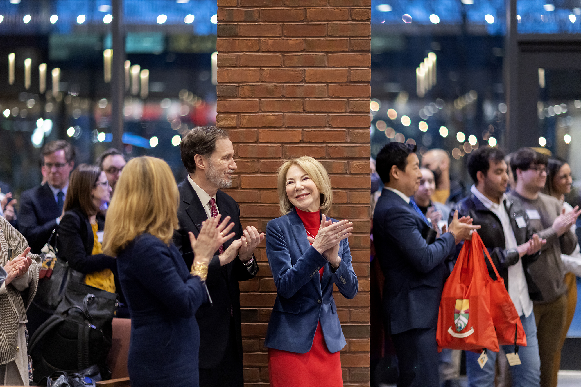 Gutmann smiles and claps in lobby of Gutmann College House