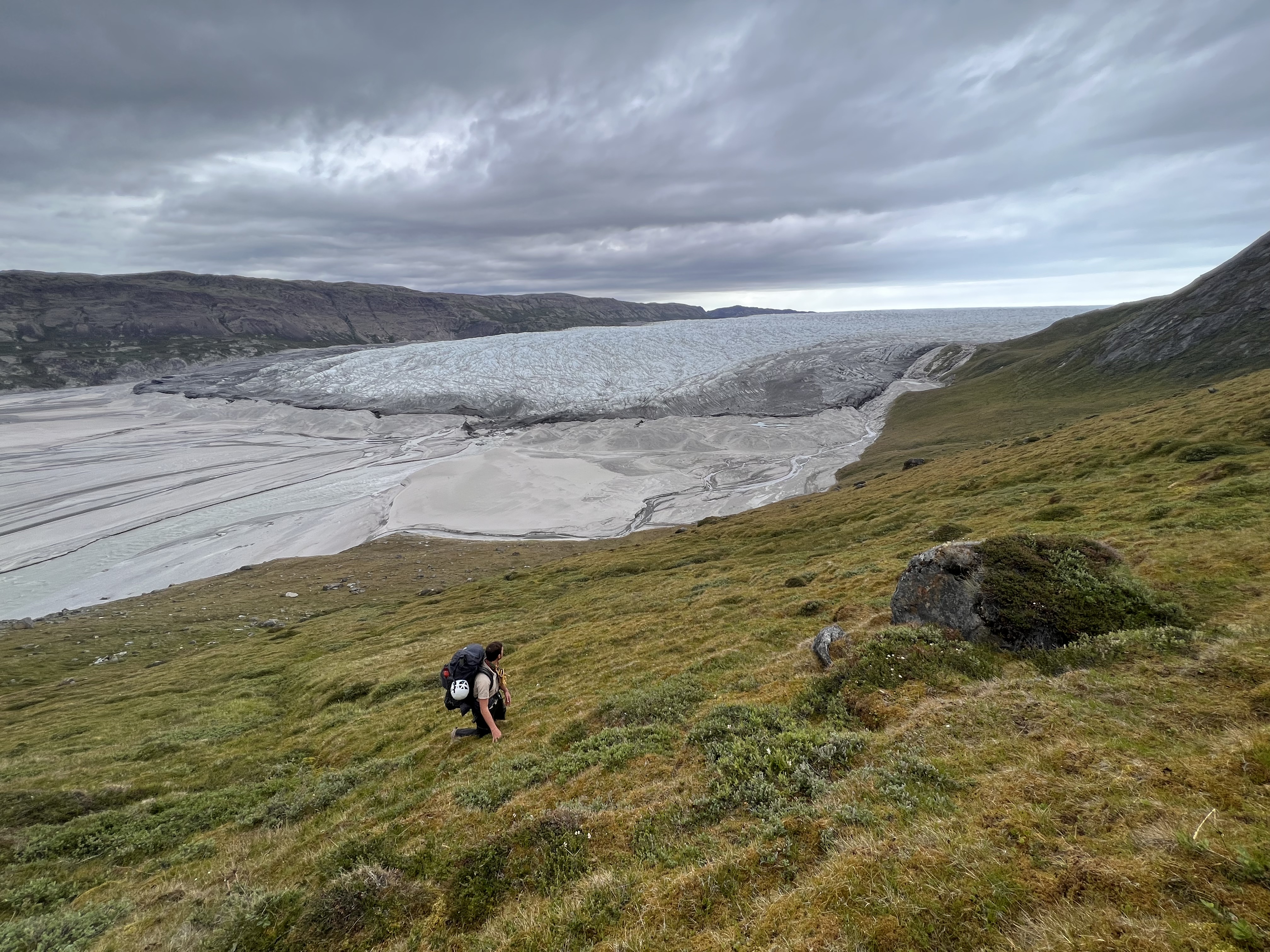 Person hikes near a large glacier
