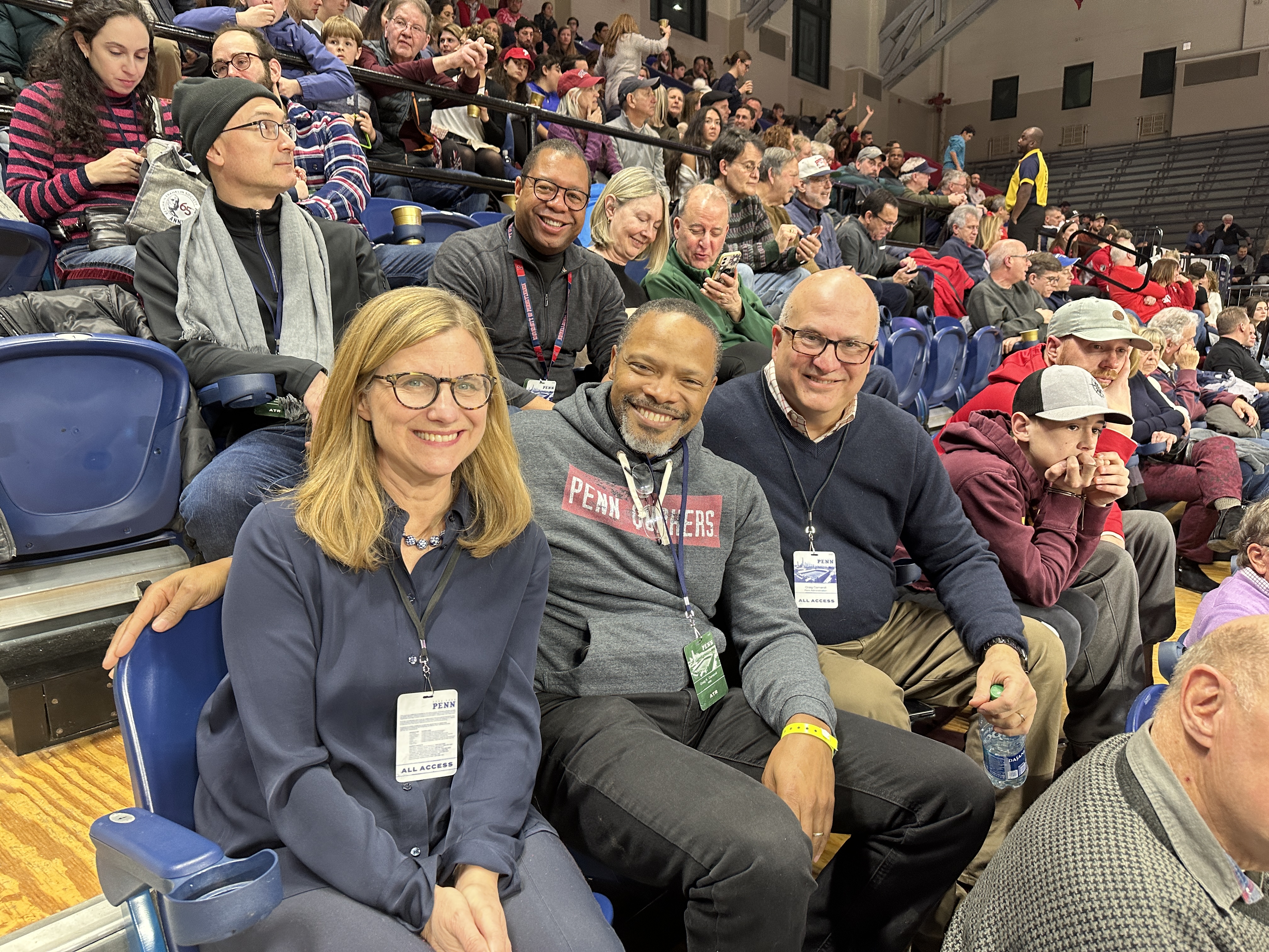From left, President Liz Magill, alumnus and Penn parent John Nixon, and Senior Executive Vice President Craig Carnaroli take in the men’s basketball game at the Palestra. Chris Bradie, a Wharton alumnus and associate vice president for the Business Services Division, is behind Nixon. 