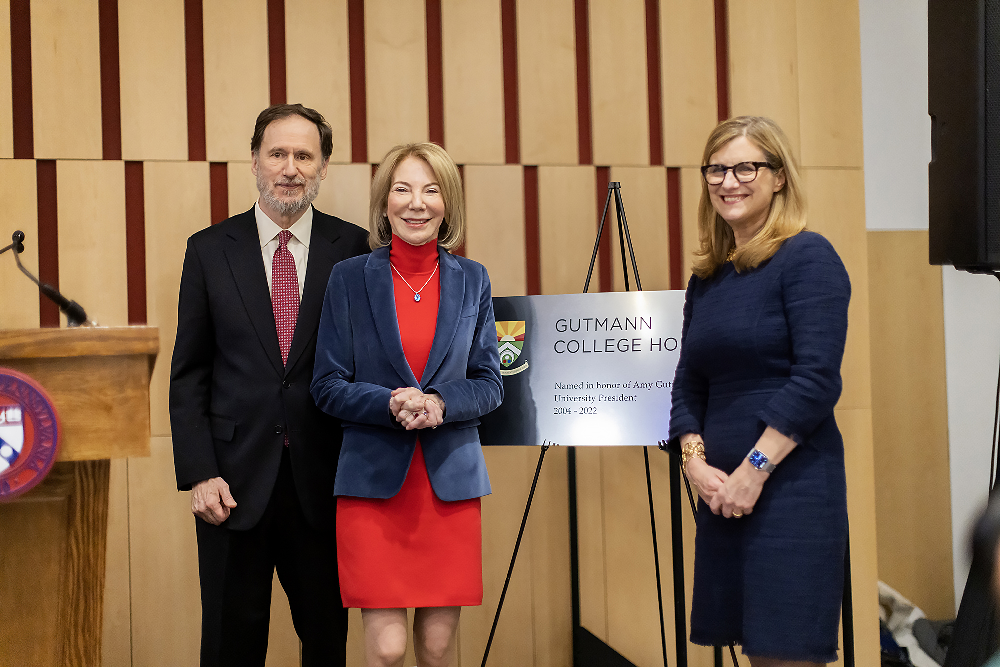 Michael Doyle, Amy Gutmann, and Liz Magill in front of a sign reading Gutmann College House.