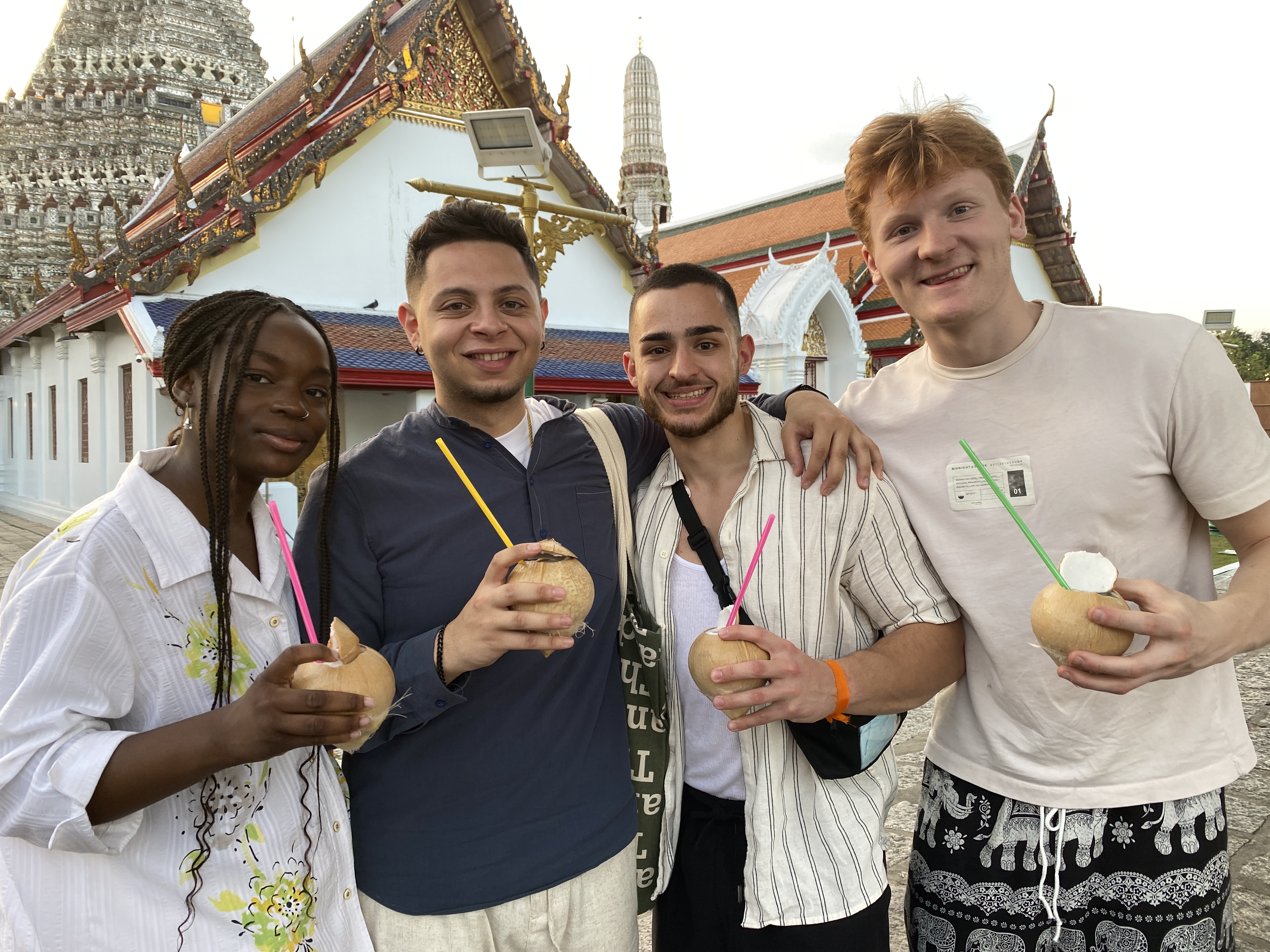 Four students pose with coconut drinks