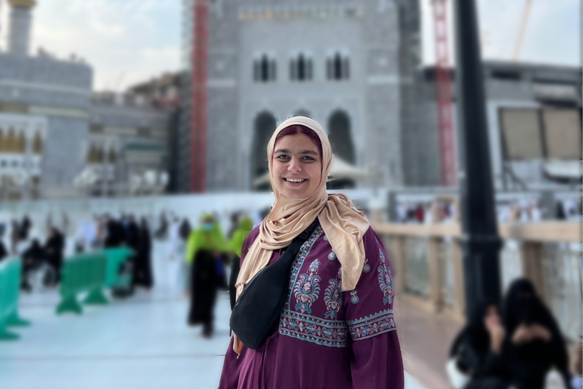 Sarah Asfari standing outside an open public square with a big building behind