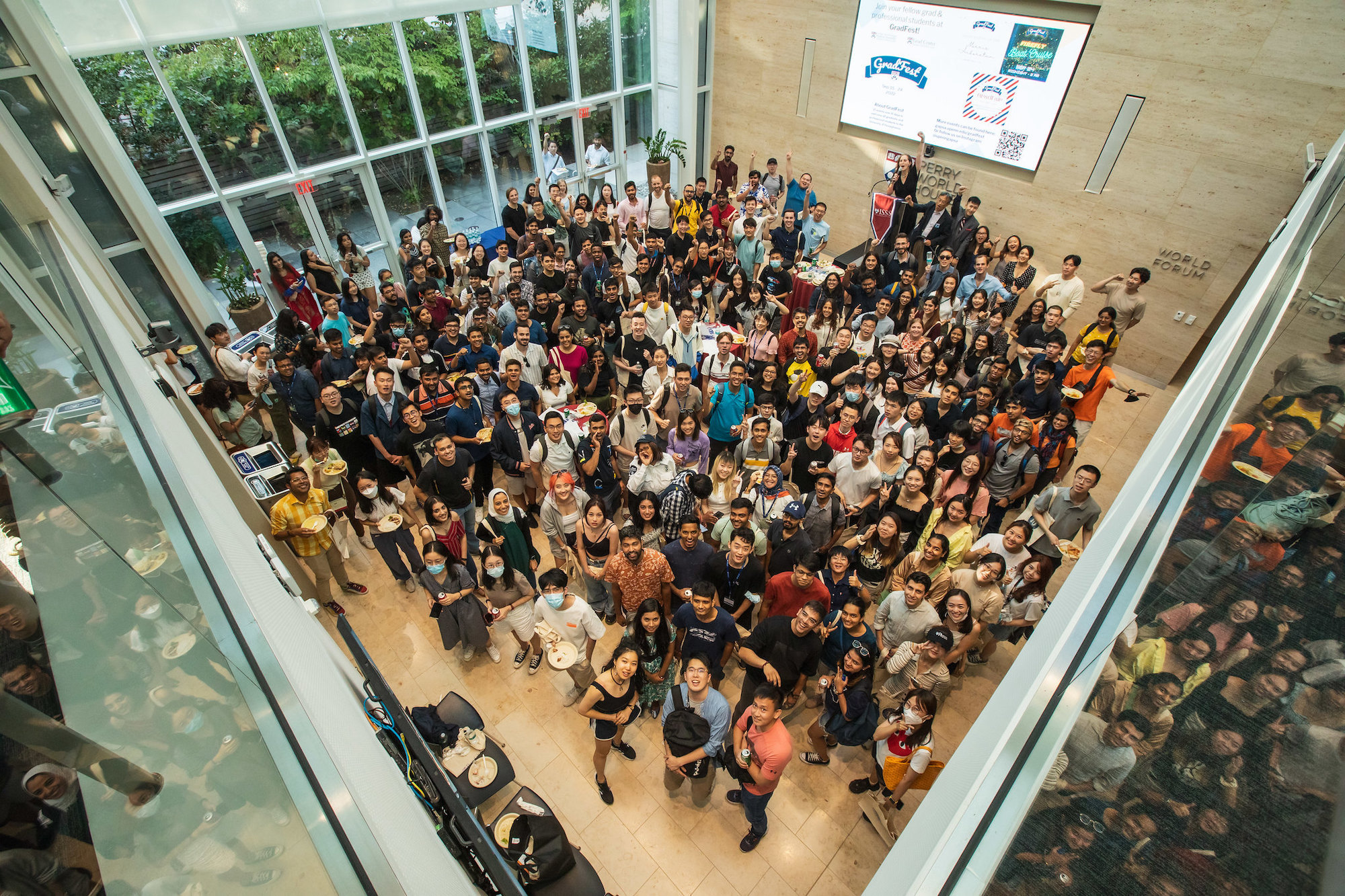 A group of international grad students is seen from above on the ground floor of Perry World House.